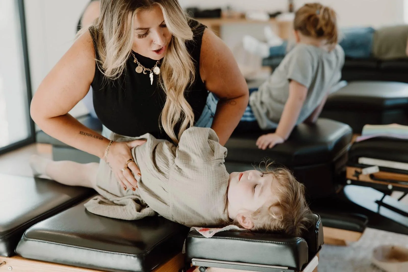 Dr. Lacey examining baby lying face-down on chiropractic table for gentle assessment — infant chiropractic care at Free Spirit Chiropractic in Tulsa