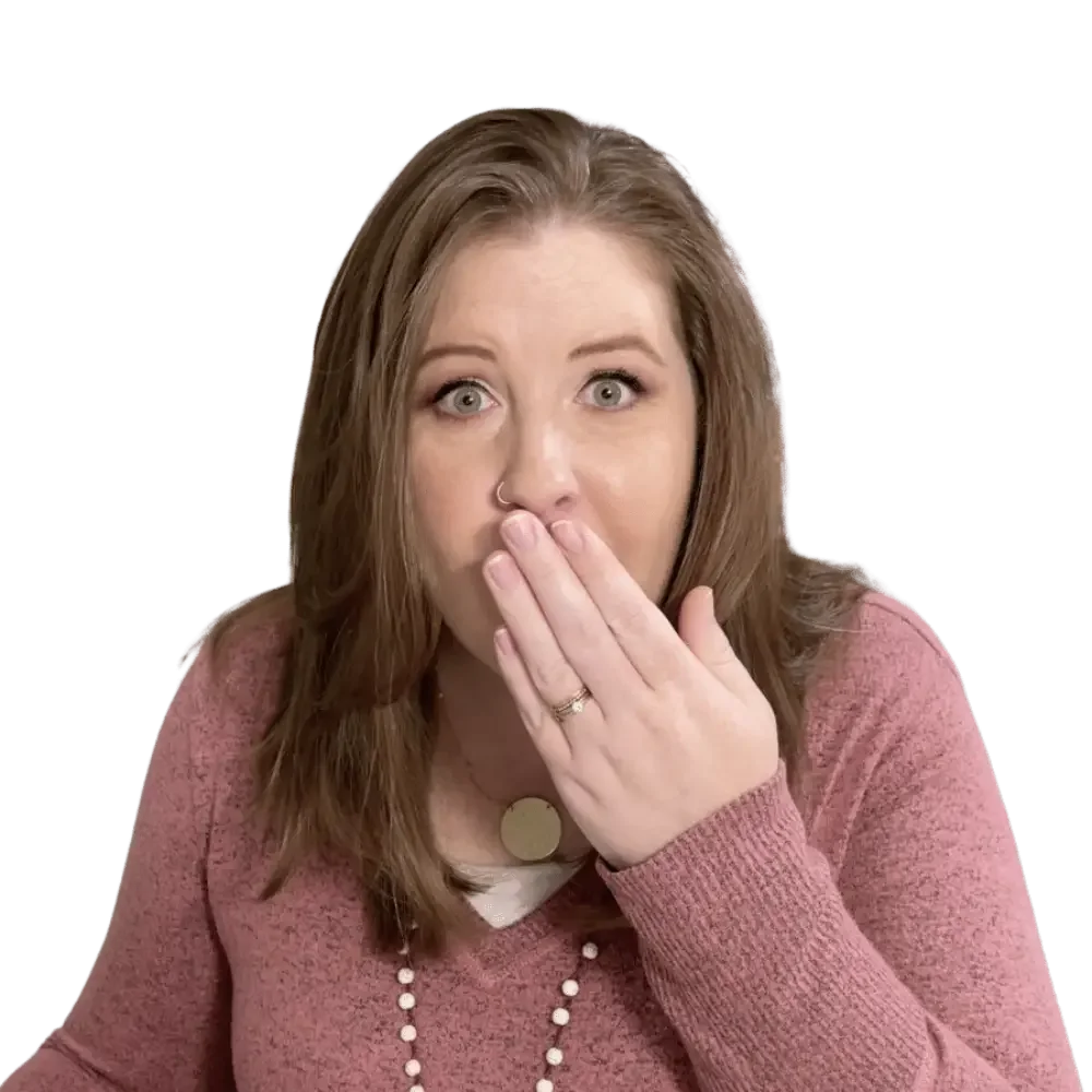 Katelyn, with long auburn hair in a pink sweater looks surprised while exploring a client portal for web designers.