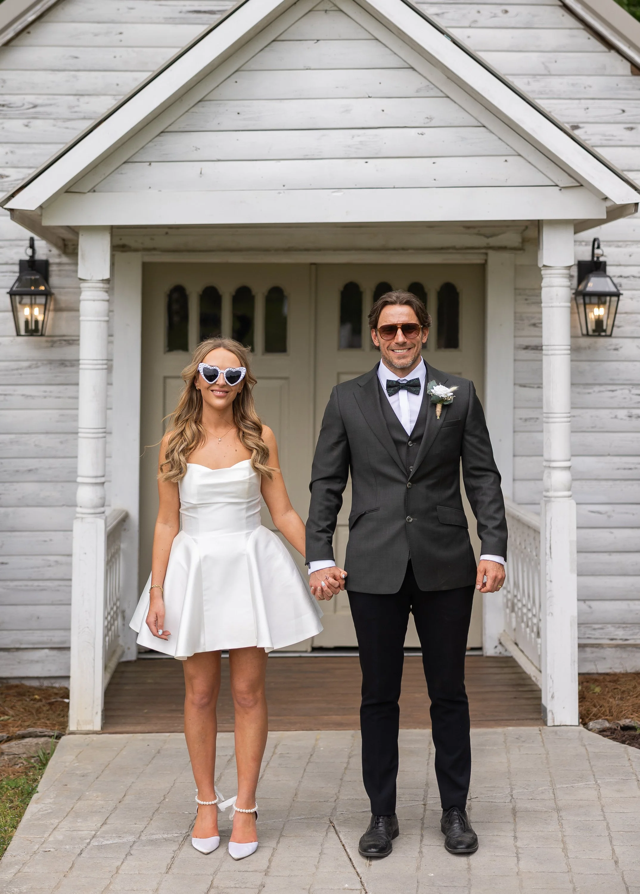 Newly married couple standing in front of a Nashville chapel where they just eloped. Smiling, happy, and holding hands