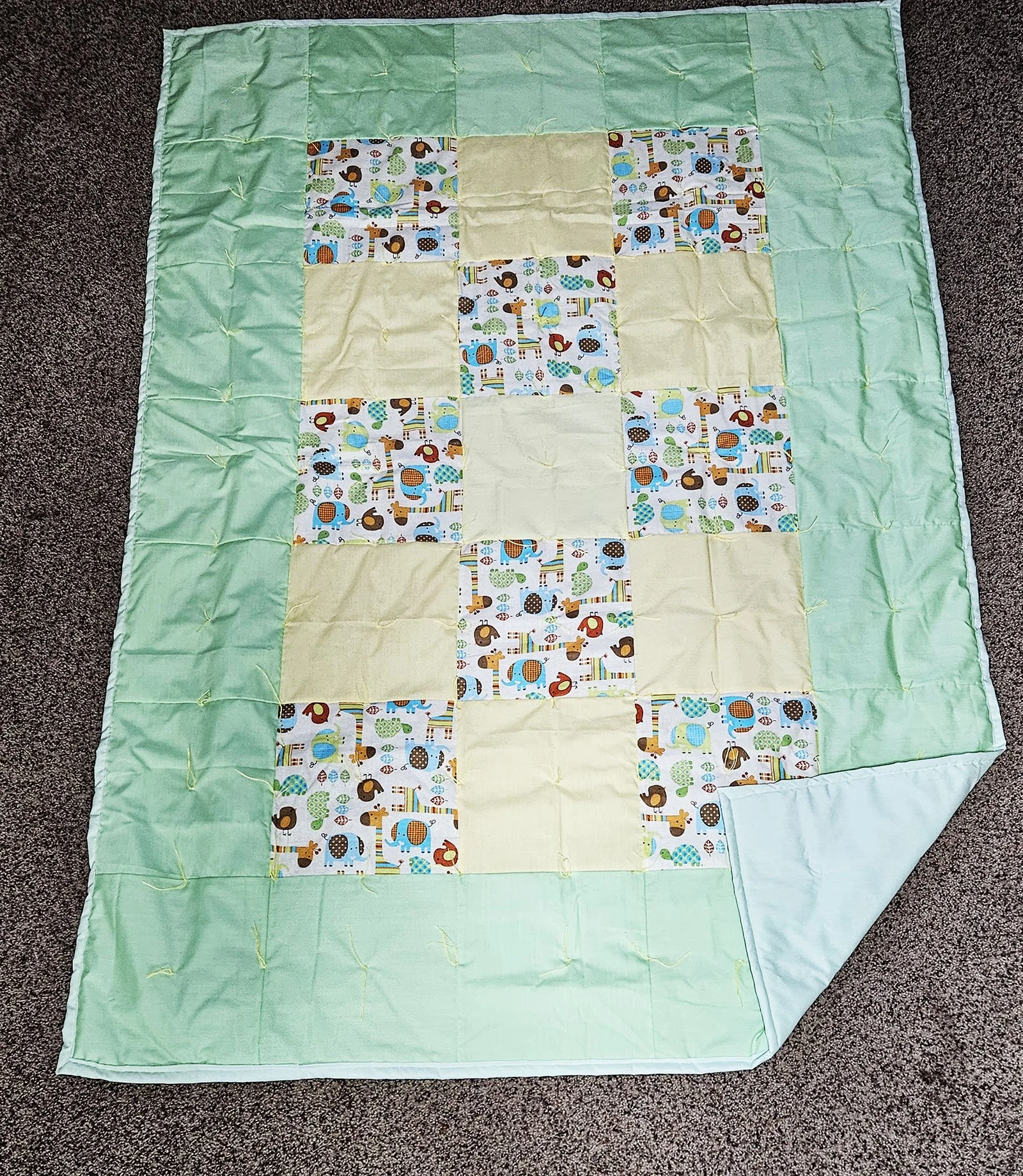 Zoo Animals, Comforter, Lap/Throw, 50x70: Bethesda Women's Ministries, Bethesda Mennonite Church

This Zoo Animal comforter is made of  10" patchwork blocks featuring giraffes, elephants, birds, and turtles, alternating with pastel yellow blocks, and