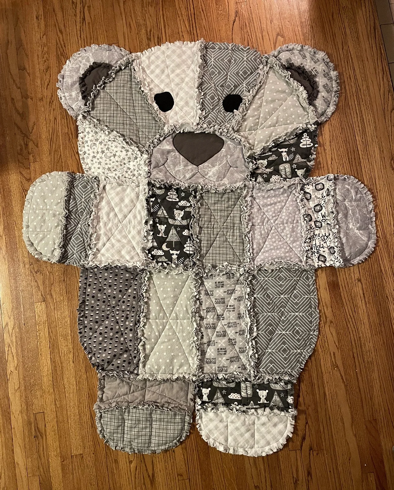 Raggy Teddy Bear, Quilt, Lap/Throw, 50x60: Tammy Riedel, First Mennonite, Lincoln

Teddy bear shaped blanket. Patchwork gray flannels on front and back. The front seams are snipped making it raggy and cuddly.