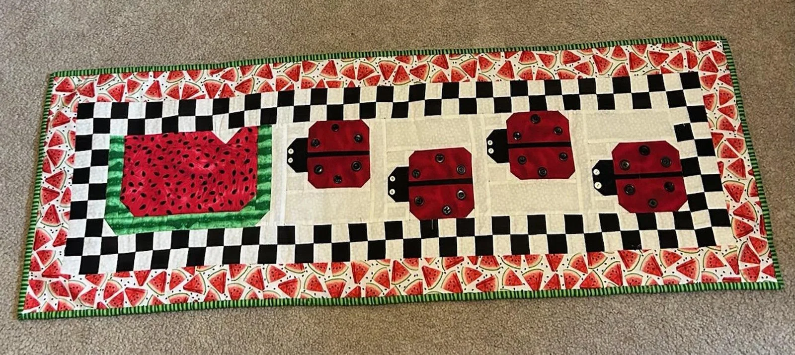 Ladybug Watermelon, Table Runner, 14x42: Rachel Crumly, Bethesda Mennonite Church

Red green and black table runner from 2014 row by row Prairie Point Quilt Shop with watermelon and ladybugs.