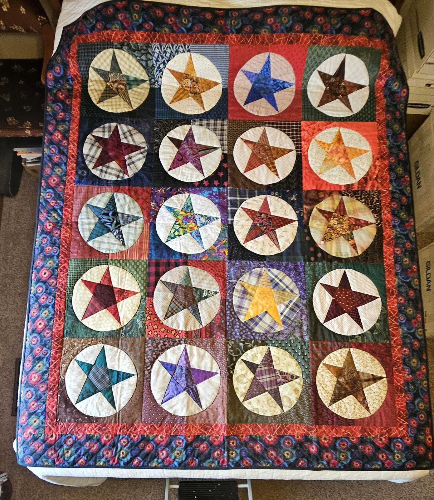 Urban Cowboy, Quilt Lap/Throw:, 62x74: Material Resources Center of Ephrata, Pa.

This fun throw quilt features wonky stars in red, blue green, yellow and gold in beige circles, surrounded by a red inner border and blue and red print outer border; pi