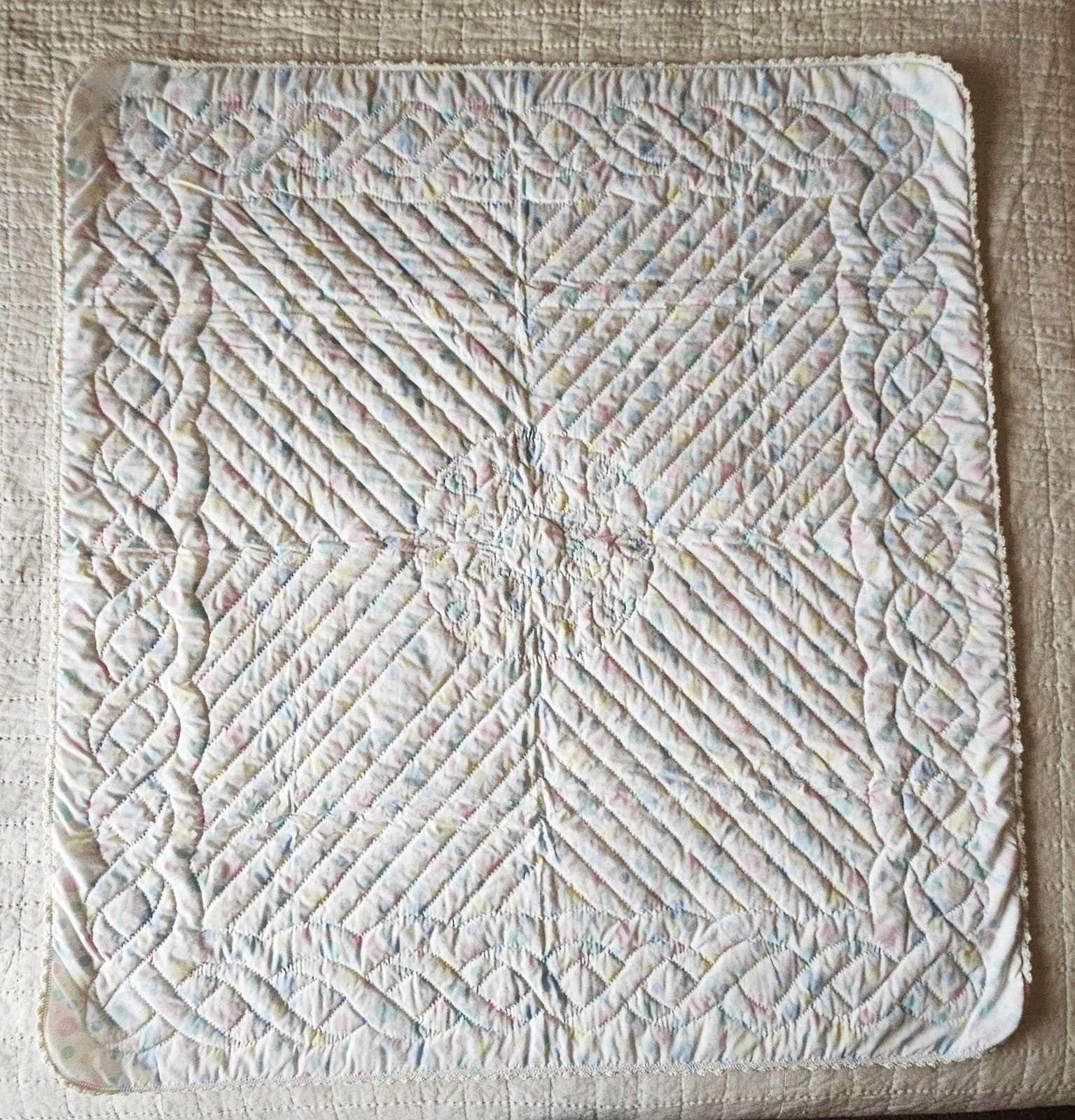 Pastel Baby Quilt, 44x48: Bethesda Women's Ministries, Bethesda Mennonite Church

This quilt has the same pastel pink, blue, yellow and green fabric on the front and back with hearts quilted in the center and ribbons quilted along the borders.  It fe