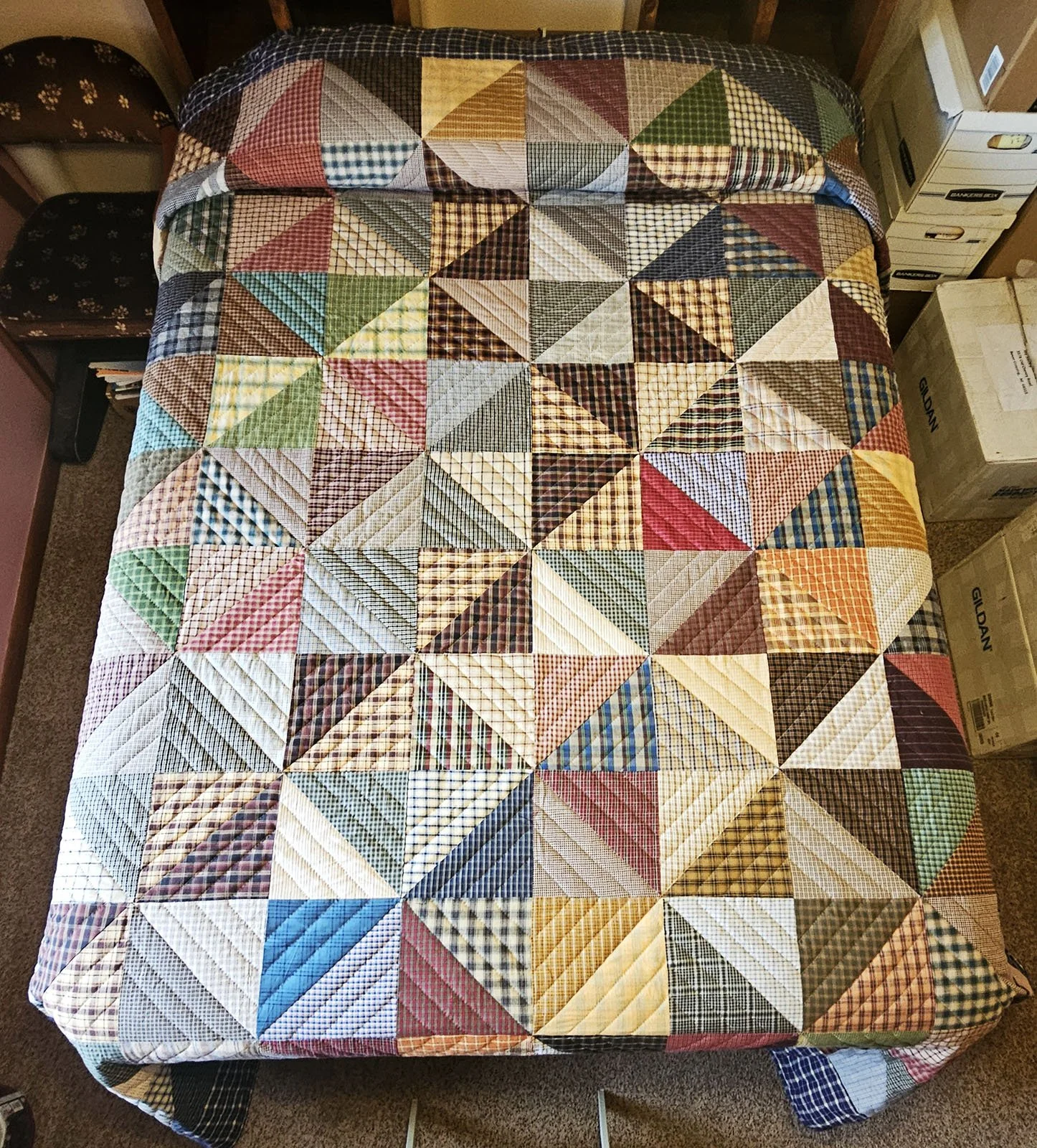 Hired Man Quilt, Queen, 96x112: Material Resources Center of Ephrata, Pa.

This quilt features half square triangles in plaids and stripes in browns, tans, reds, greens and golds, reminiscent of men's work shirts, with a navy blue plaid outer border;