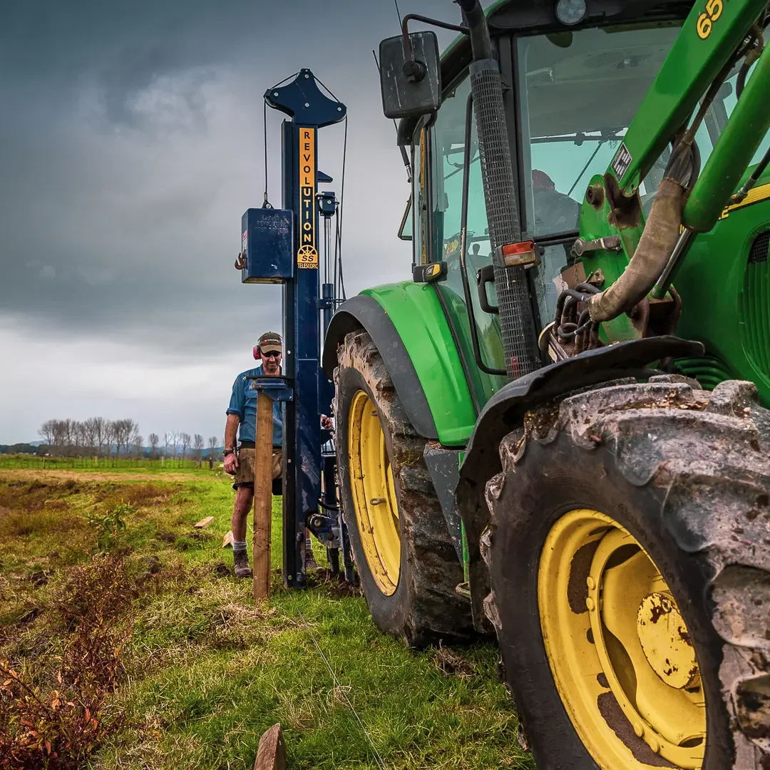 12-revolution-ss-post-driver-john-deere-operator-standing-overcast-compressed.webp