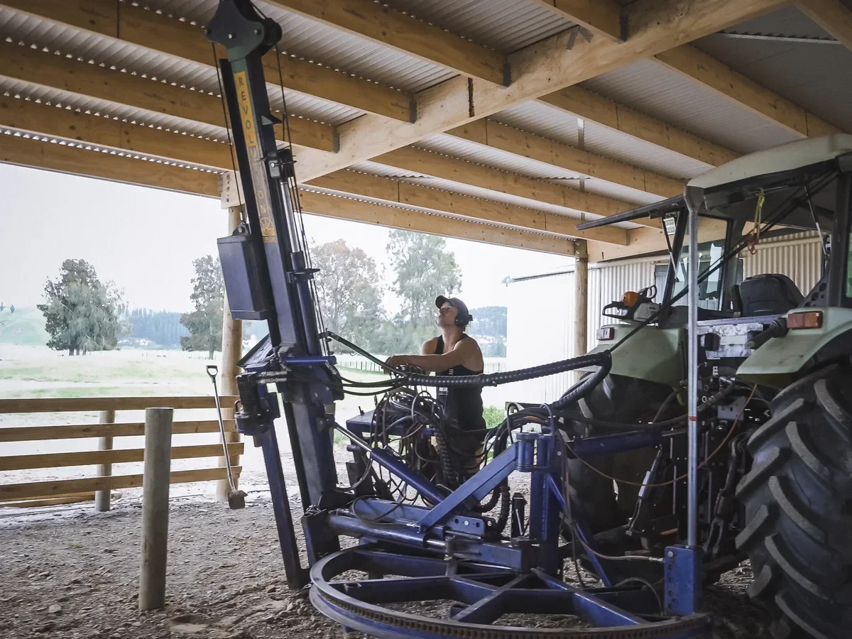 Operator with a Revolution 180 post driver inside a farm shed