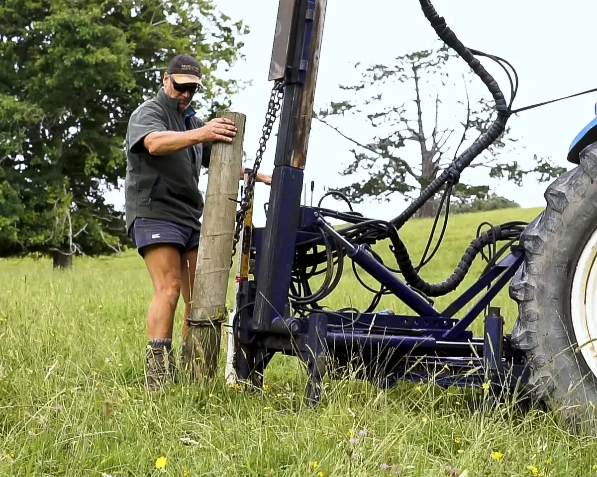 Revolution 180 post driver pulling a fence post from the ground on a farm