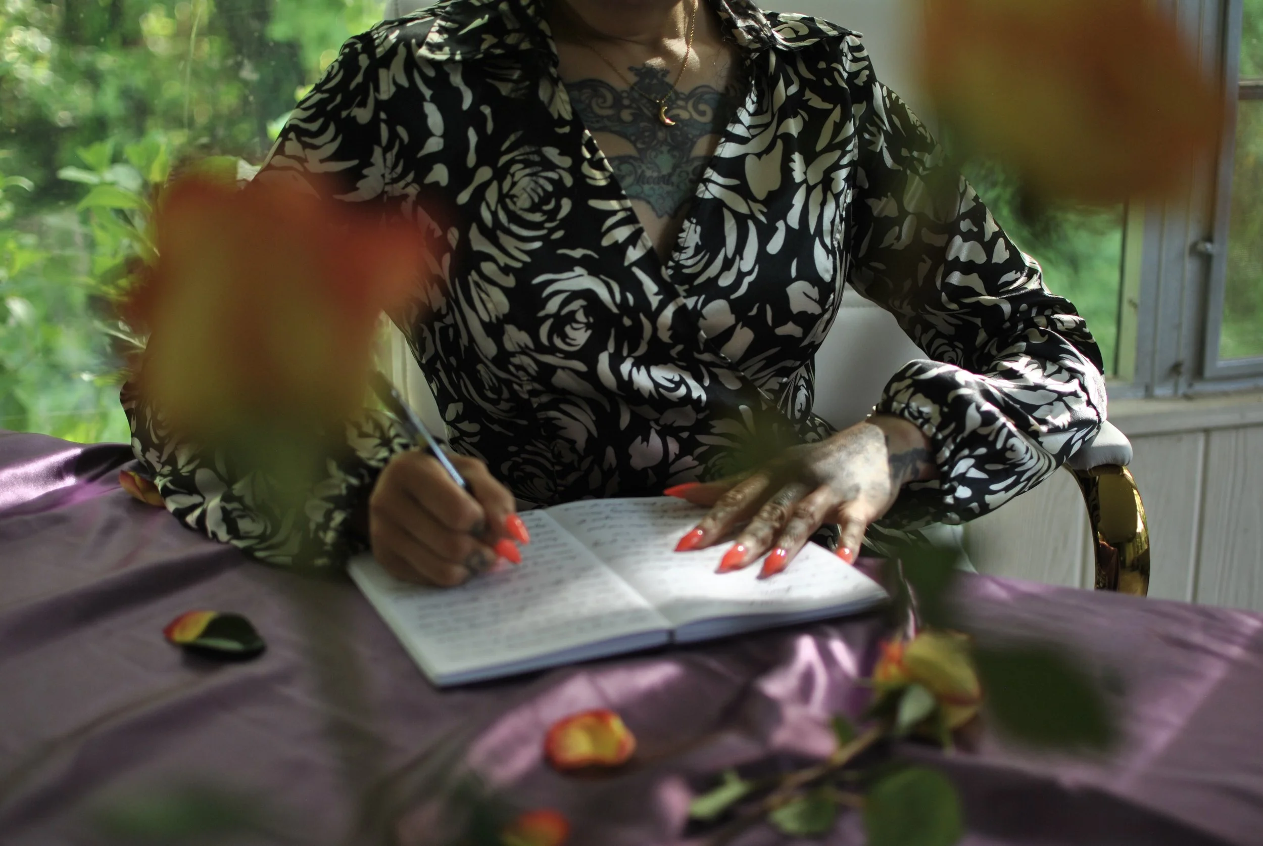 picture shows myself seated at a desk with an open journal i am writing in. exploring the full moon in scorpio with three journal prompts that encourage using this astrological transit as a time to explore transformative shadow work.