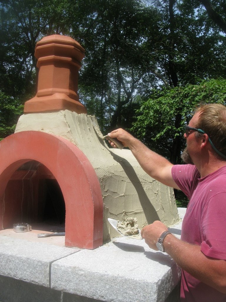 John applies a thin layer of cement to cover the dome.