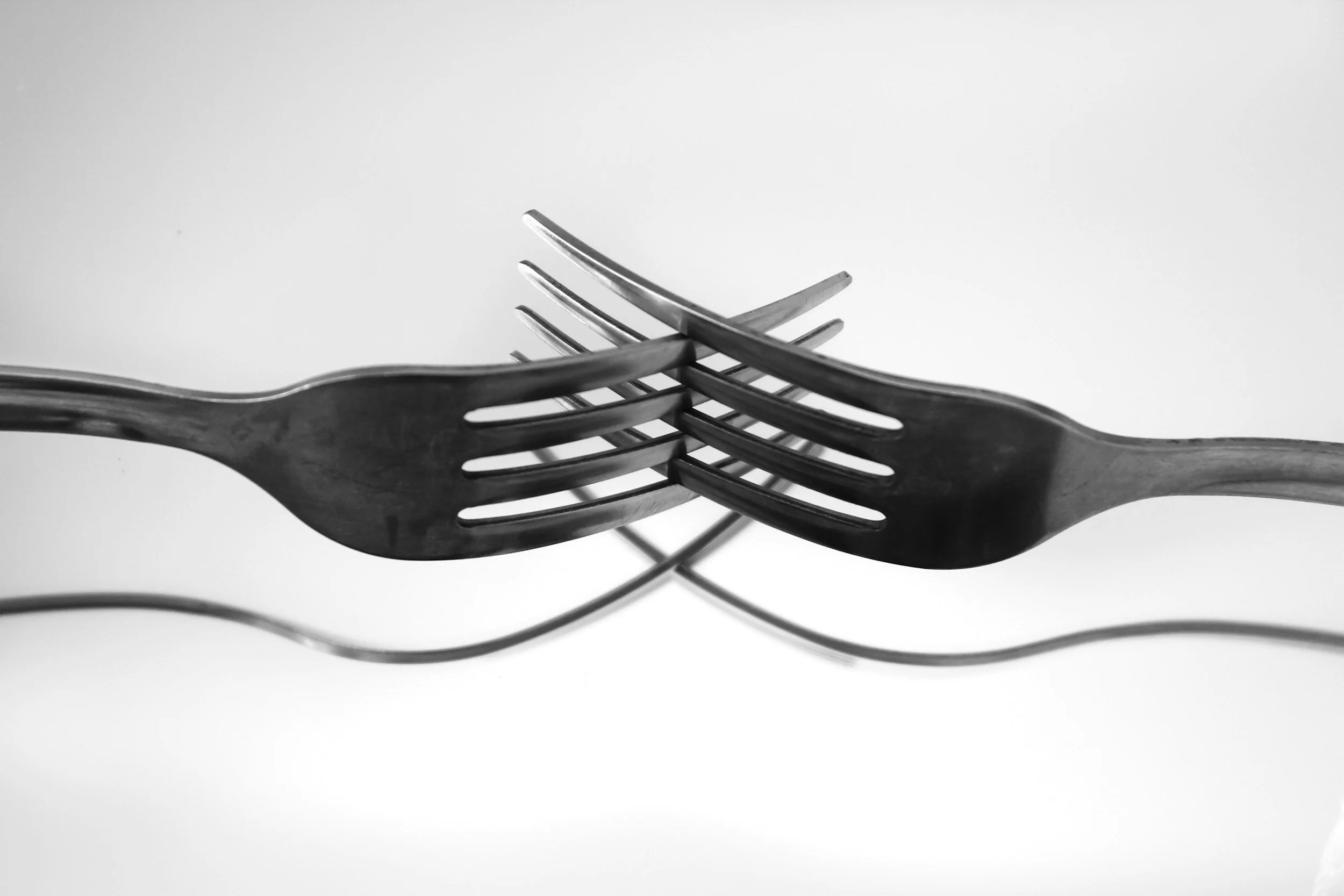 photo of two forks intertwined with each other