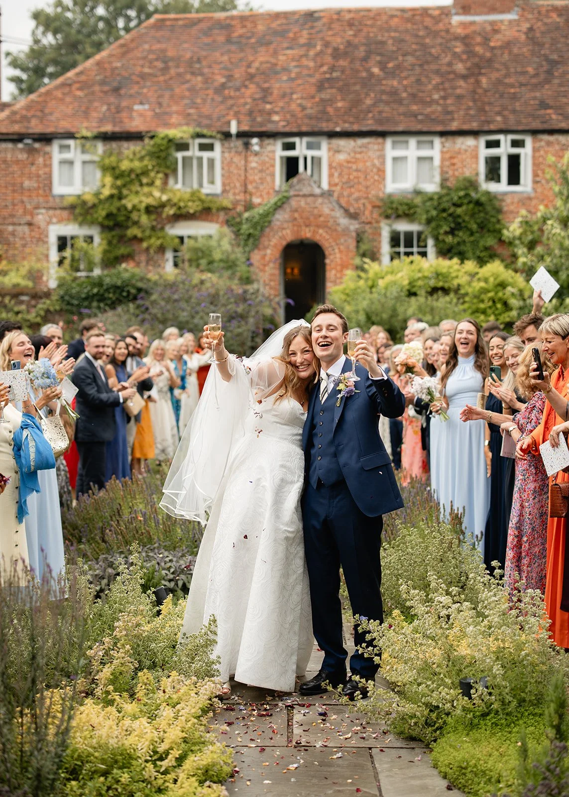 A smiling Bride and groom after confetti in the gardens at Uptown Farm House.