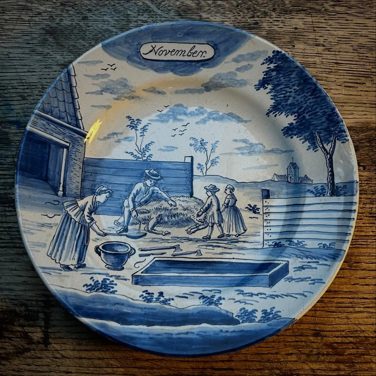 Two nice antique Dutch Delft calendar plates for November and July. Hand painted with figural scenes.

Similar plates online are mostly 1990&rsquo;s reproductions from the Metropolitan museum of Art, based on the 18th century originals from their col