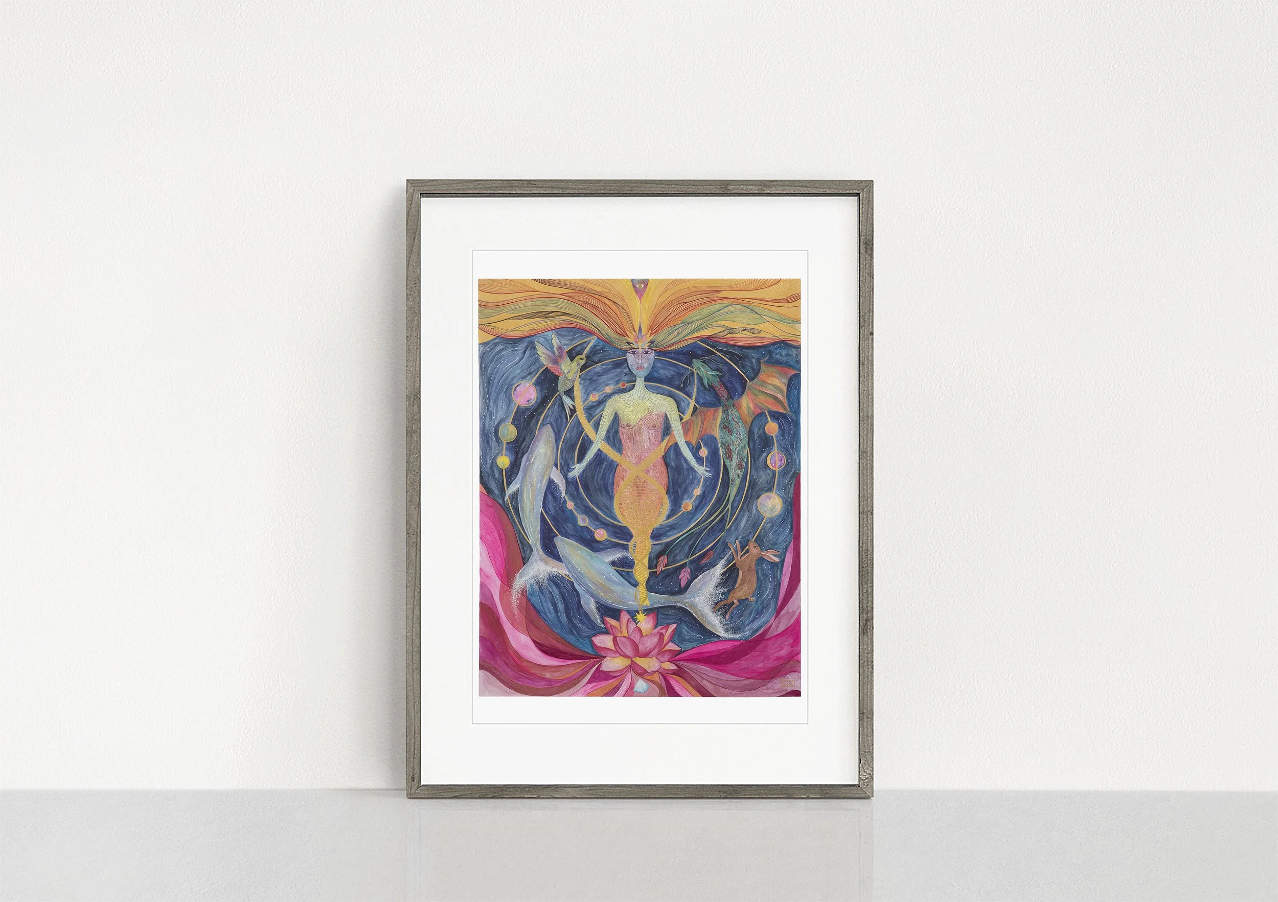 A frame on a table containing an image of a painting with an ethereal figure, whales, hare, hummingbird, dragon, a lotus flower and streams of consciousness