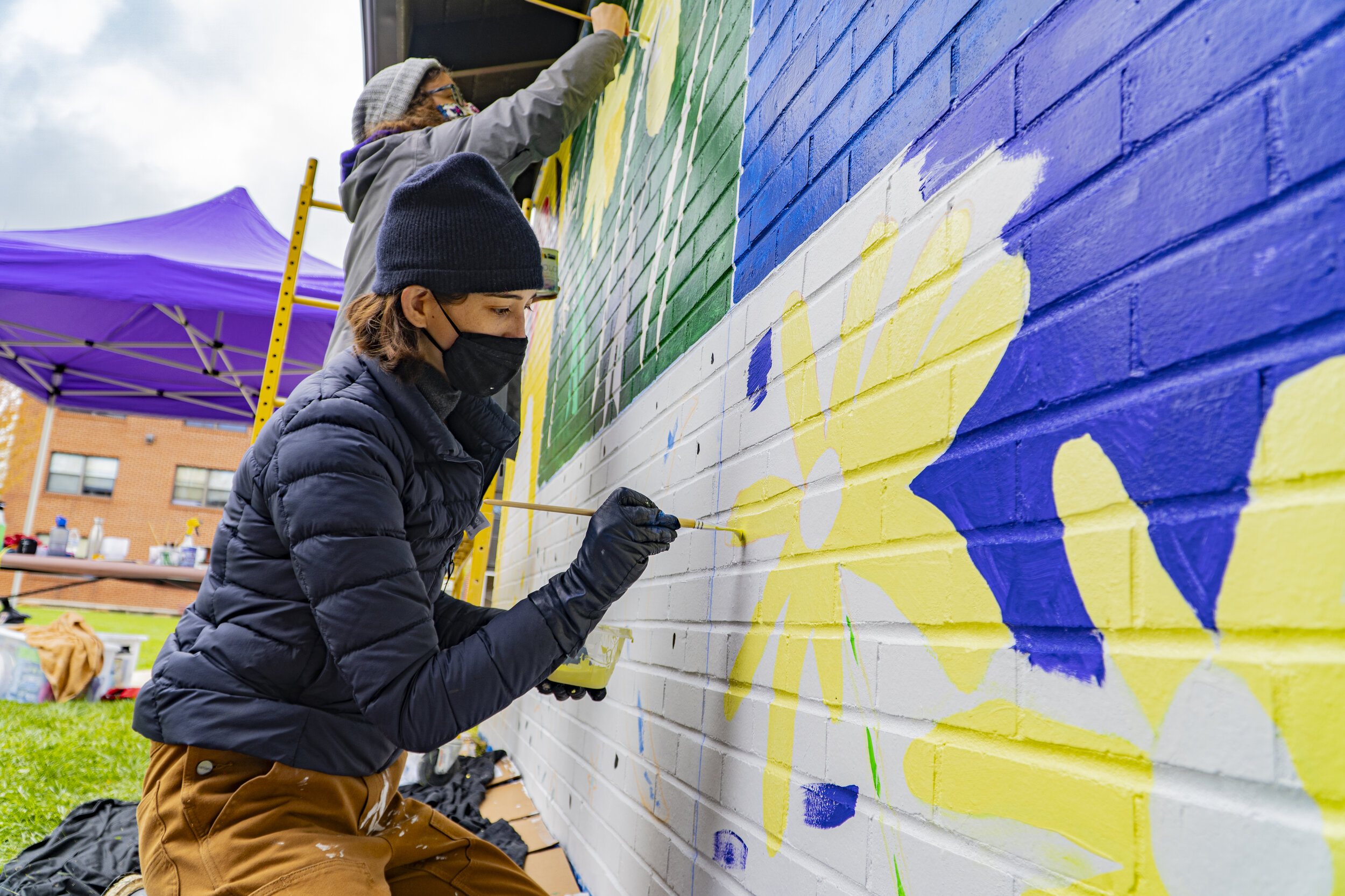 Liesel Plambeck works with students on the new mural located on the Sustainability Building. (Rob Nguyen/TKS)