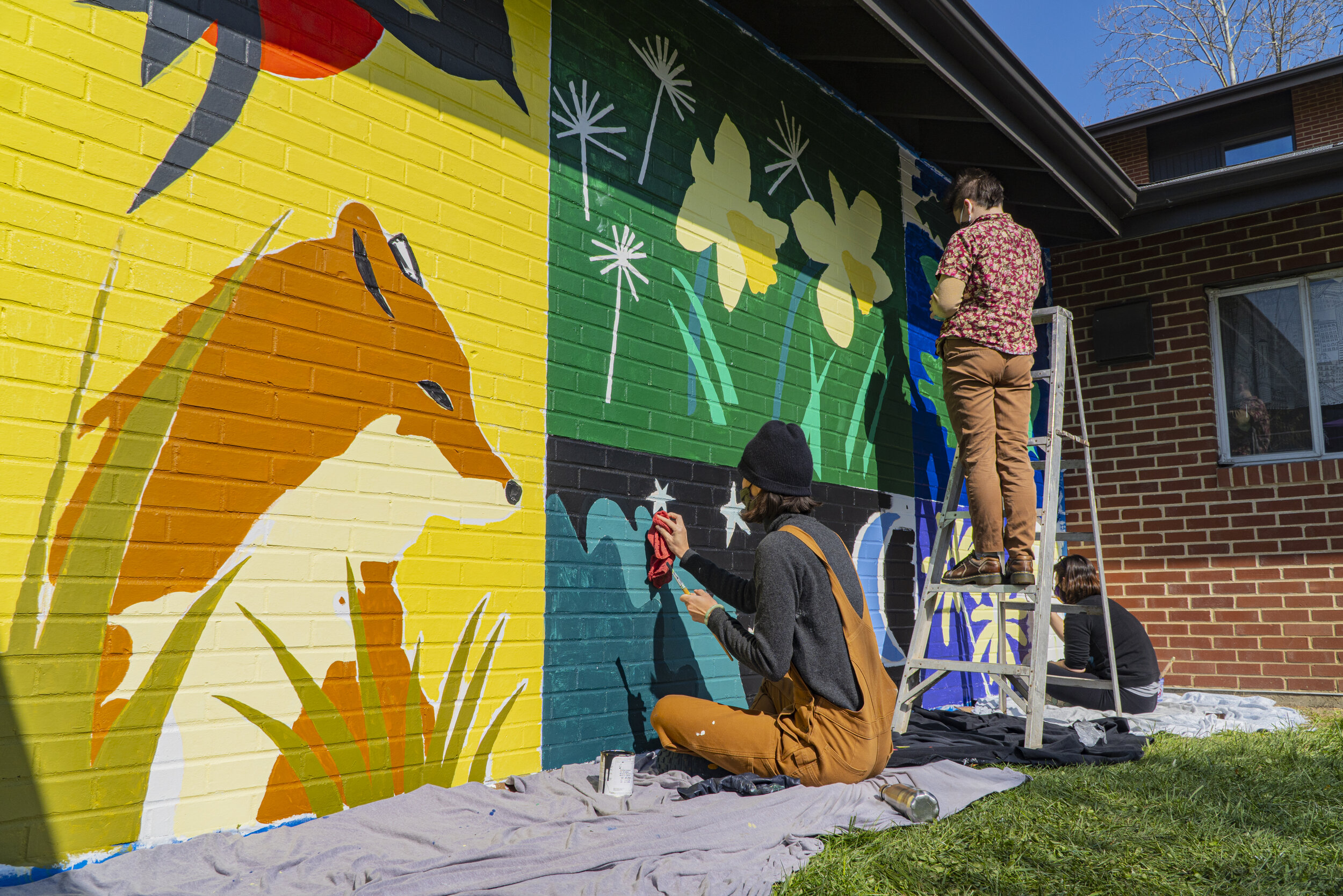 Students  continue working on the mural using ladders to reach all areas. (Rob Nguyen/TKS)