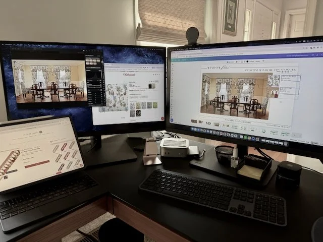 Interior designer workspace showing presentation documents being prepared on computer monitors