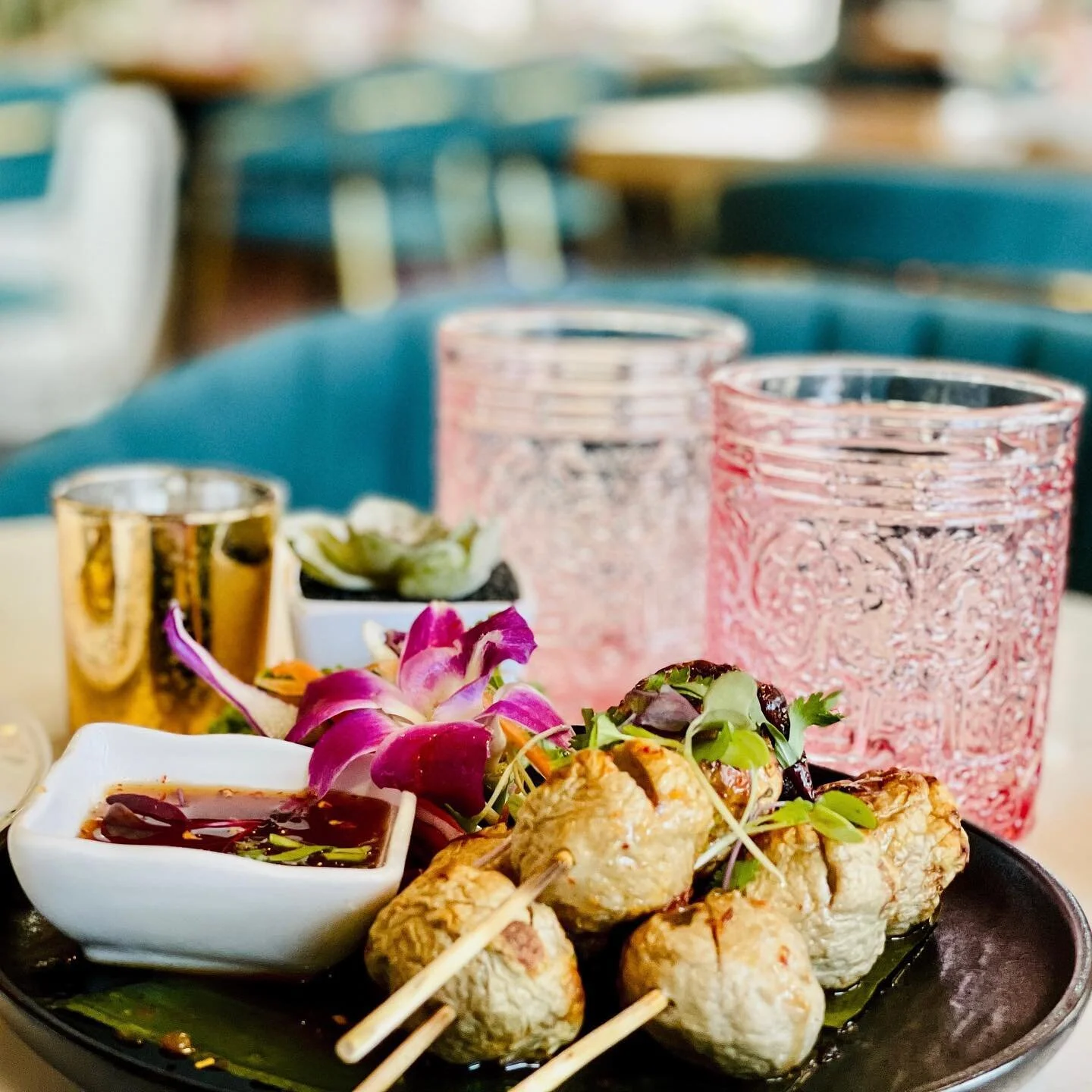 Luk Chin Ping - Thai pork meatballs. Grilled on skewers and served with a house made spicy sauce.