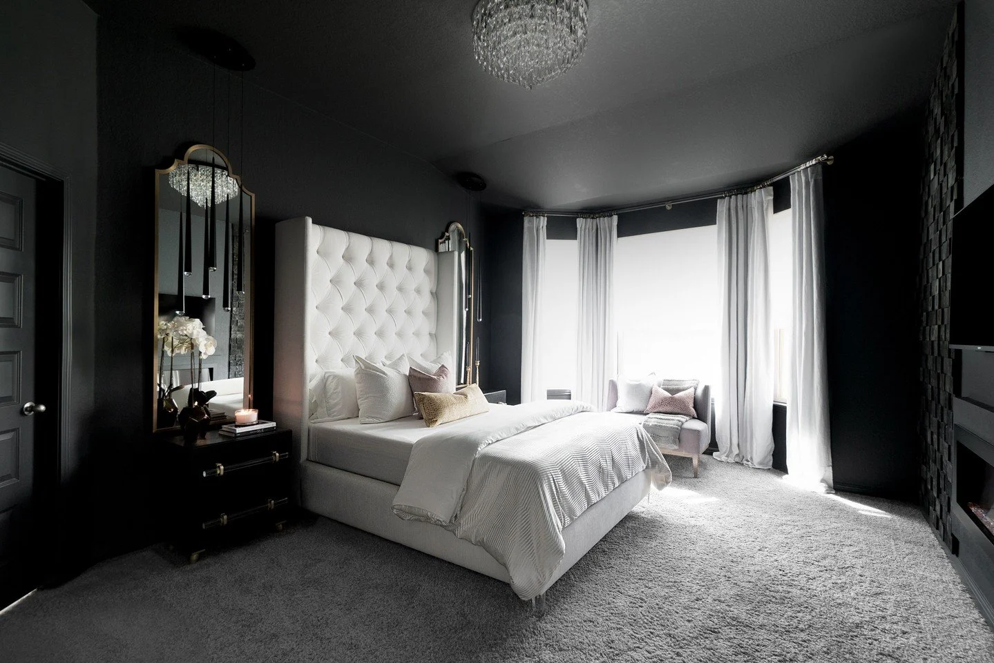 Bold but classic -- a study in contrast and confidence.

This dark and moody bedroom proves that black can be both bold and serene. Every surface is color-drenched in rich black tones, balanced by soft white upholstery, bedding, and curtains that fra