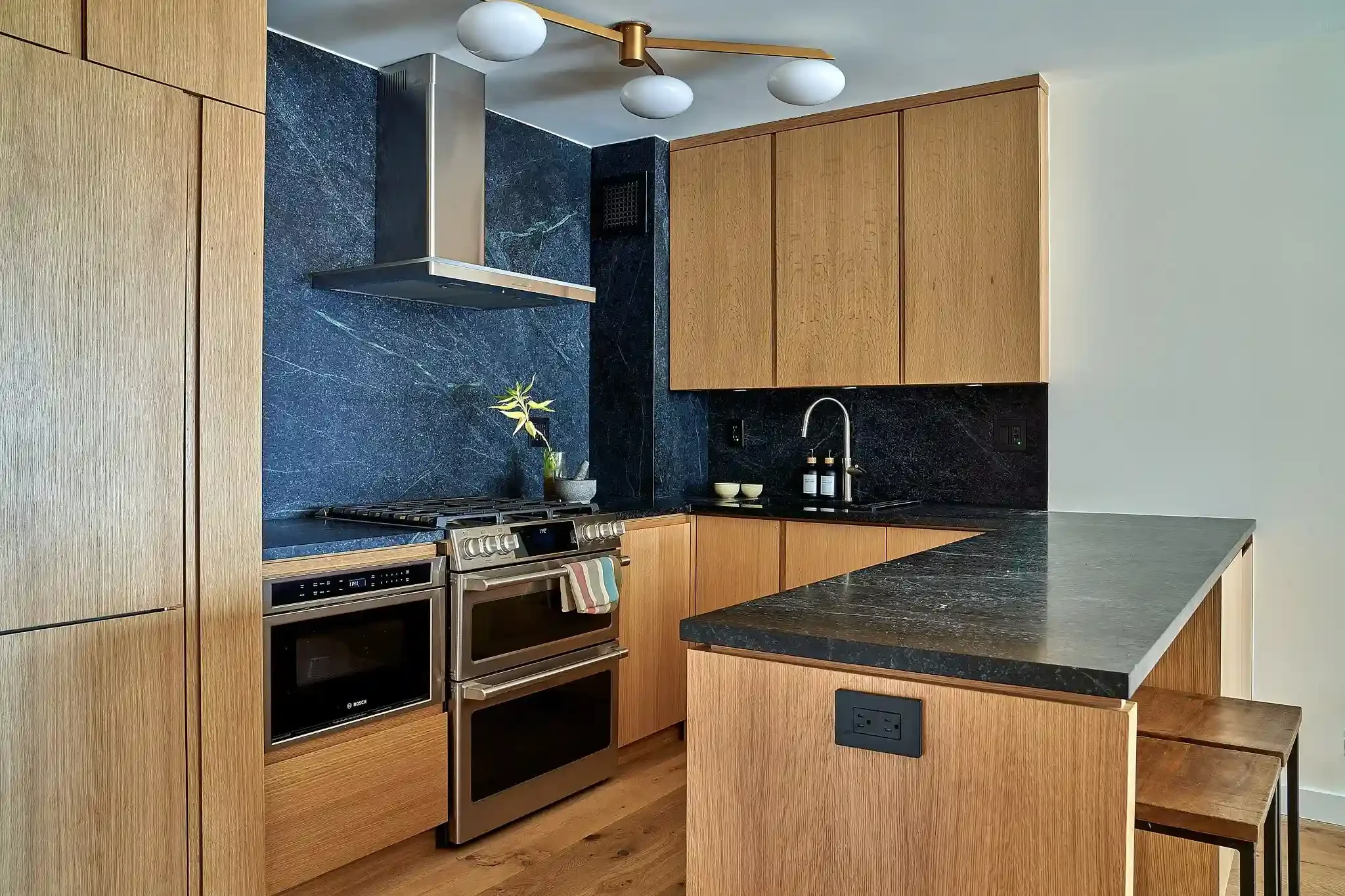 Wood and black marble siding in modern NYC kitchen
