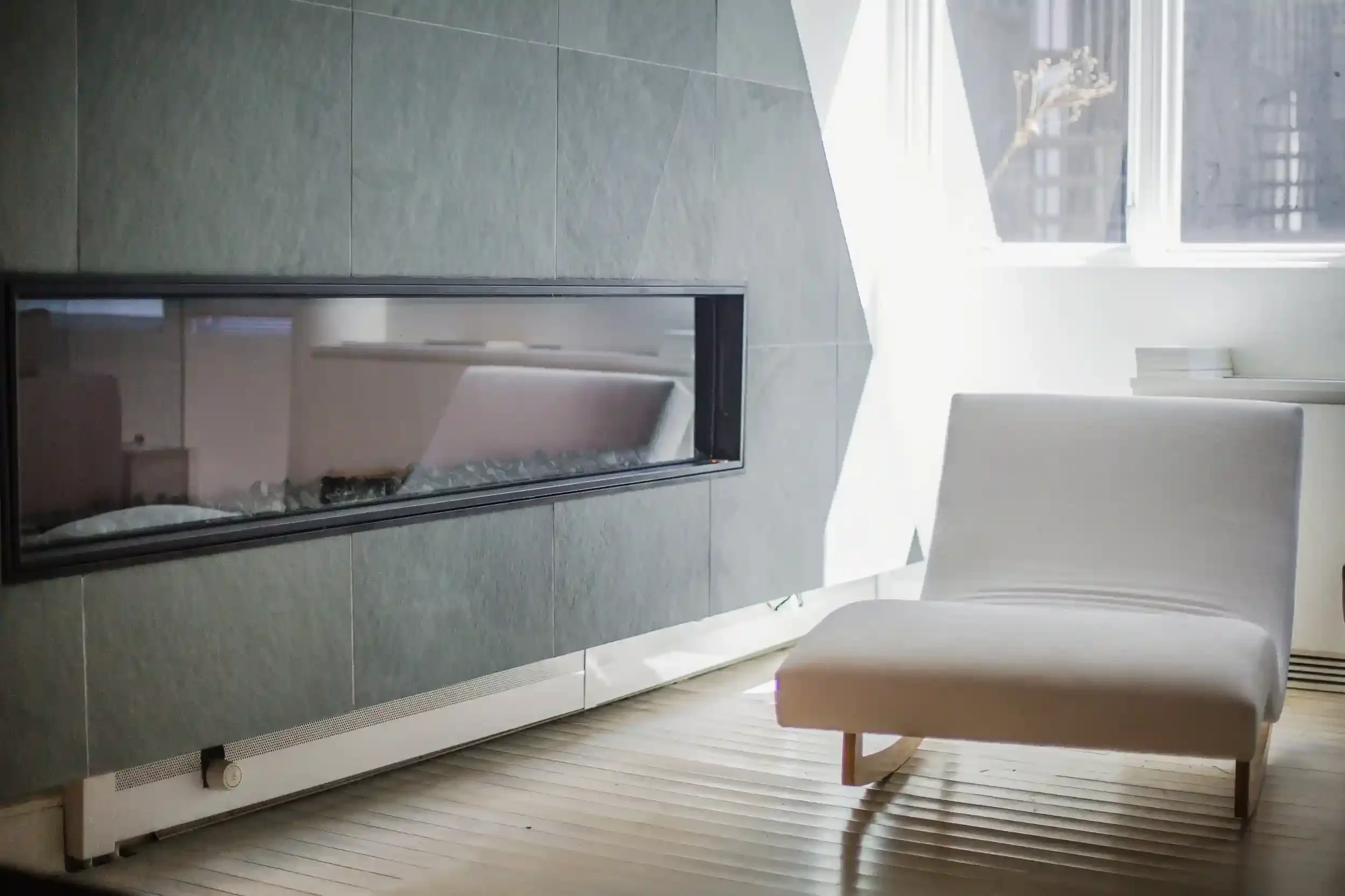 Living room with green slate wall, fireplace, and lounge chair