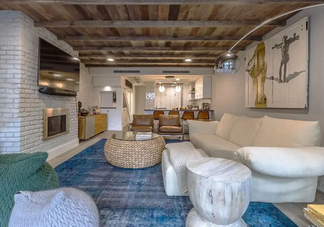 Living room with blue rug and white sofa in NYC apartment