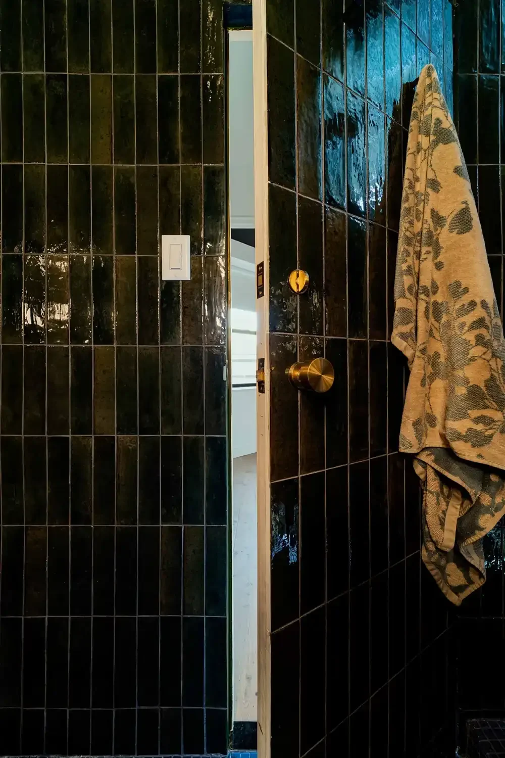 Dark tiled shower door of a detailed revamp of a studio apartment in Manhattan's Gramercy district