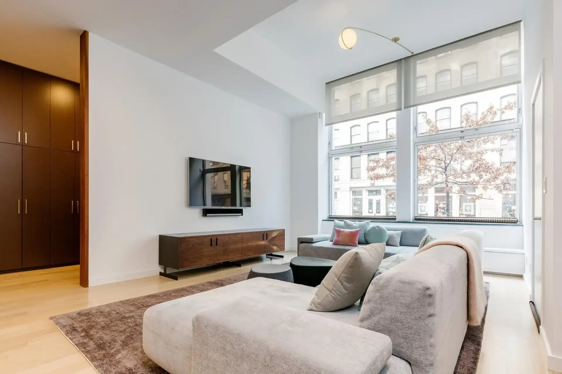 Living room in NYC apartment with TV stand and sectional