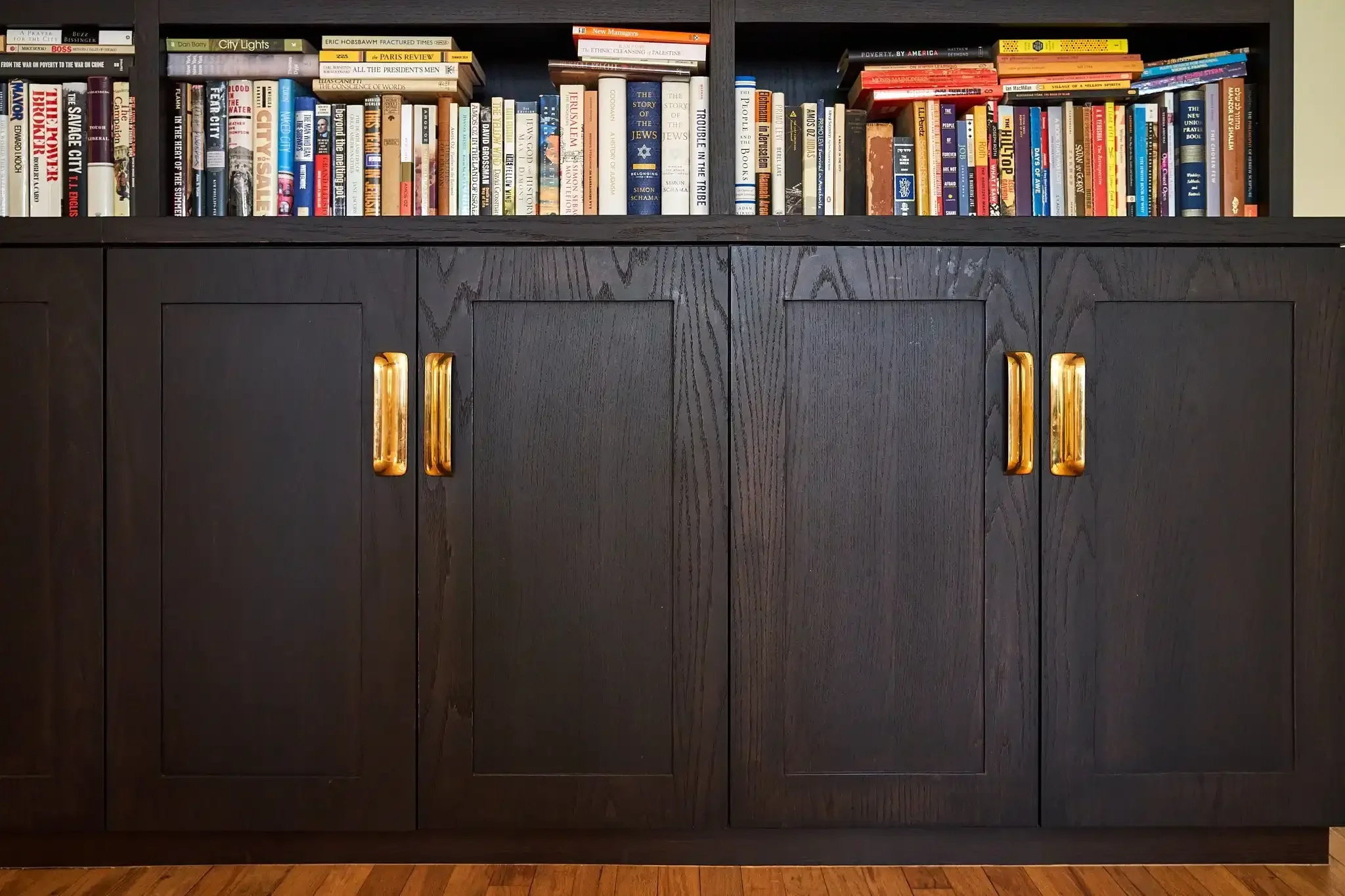 Black cabinets with gold handles with books on it