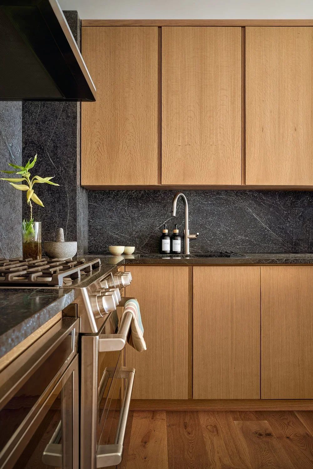 Wood cabinets, slate walls, and oven in modern kitchen