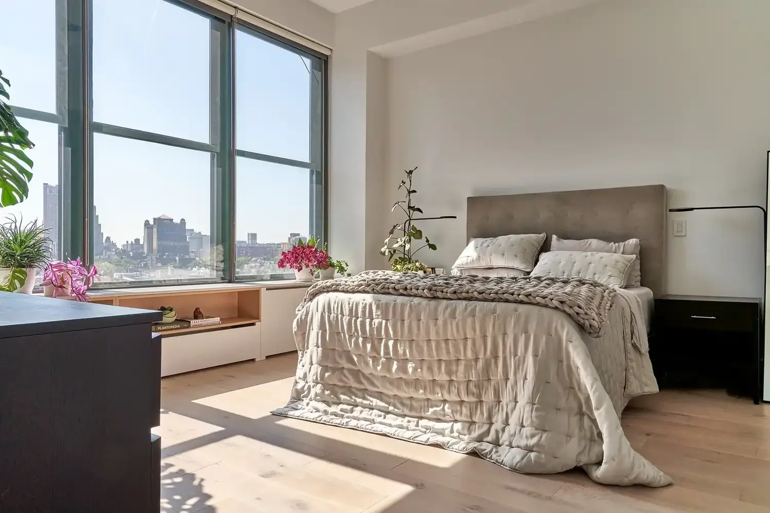 Bedroom in NYC apartment with bedding and plants
