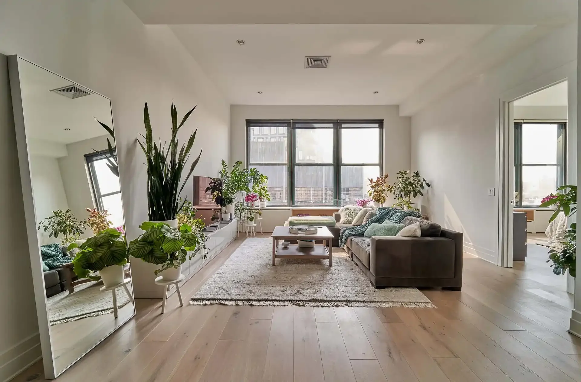 NYC apartment living room with plants and wall mirror