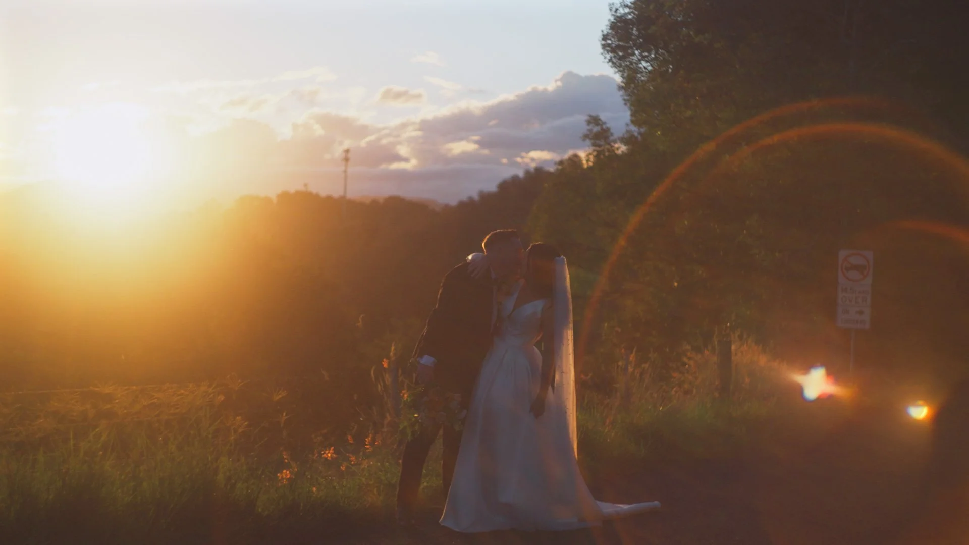 bride and groom kissing in the sunlight overlooking kingscliffe .jpg