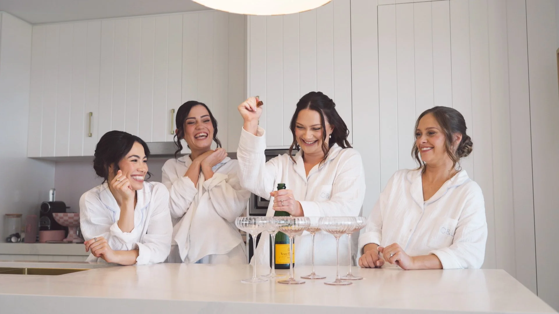 bride and bridesmades popping wine.jpg