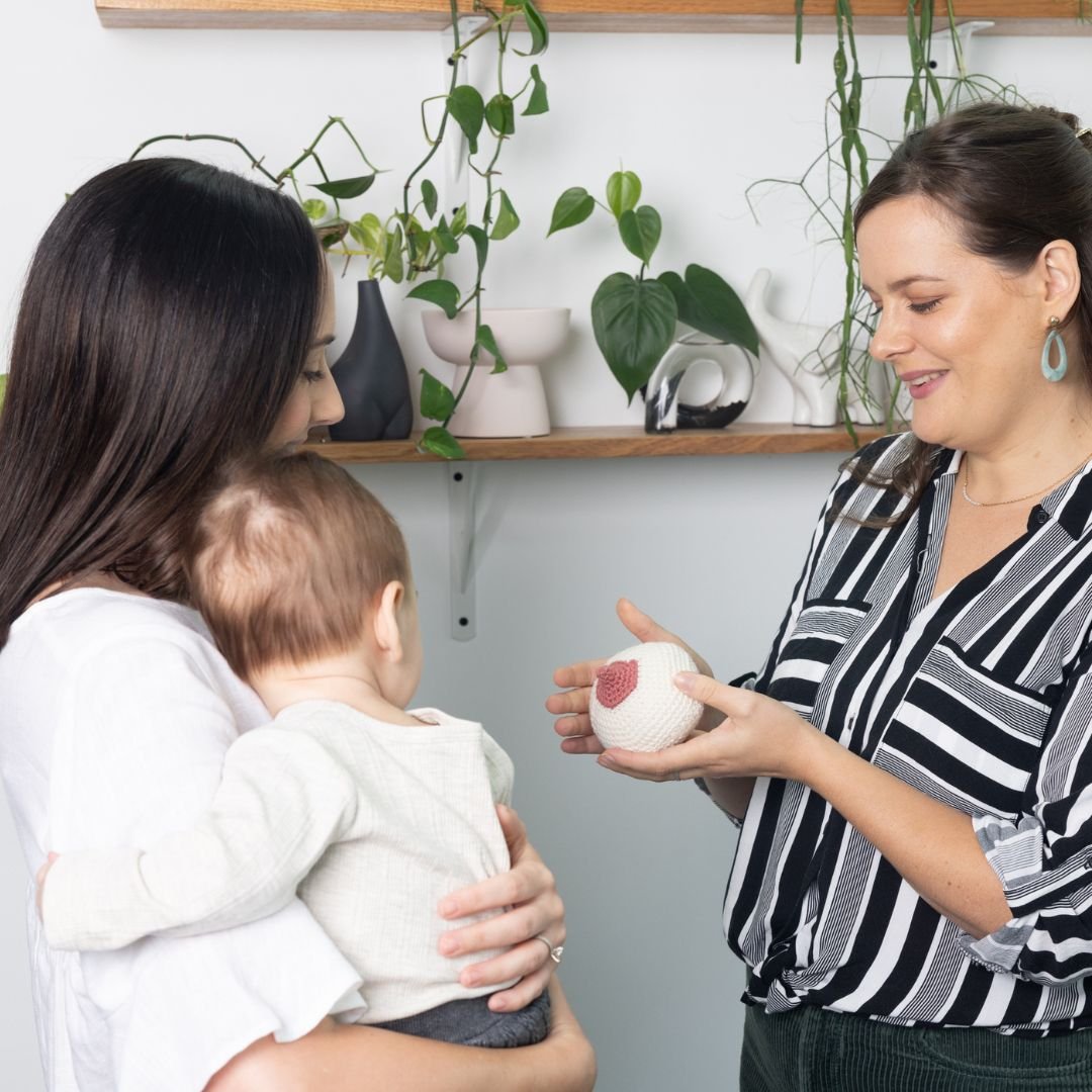 Osteopath supporting a postpartum mother with breastfeeding-related mastitis concerns