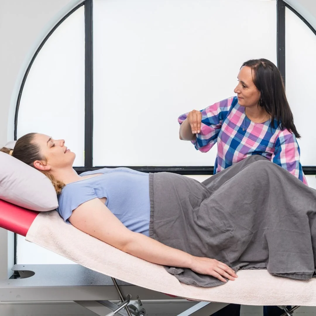 Osteopath explaining pelvic floor examination procedures to a pregnant patient.