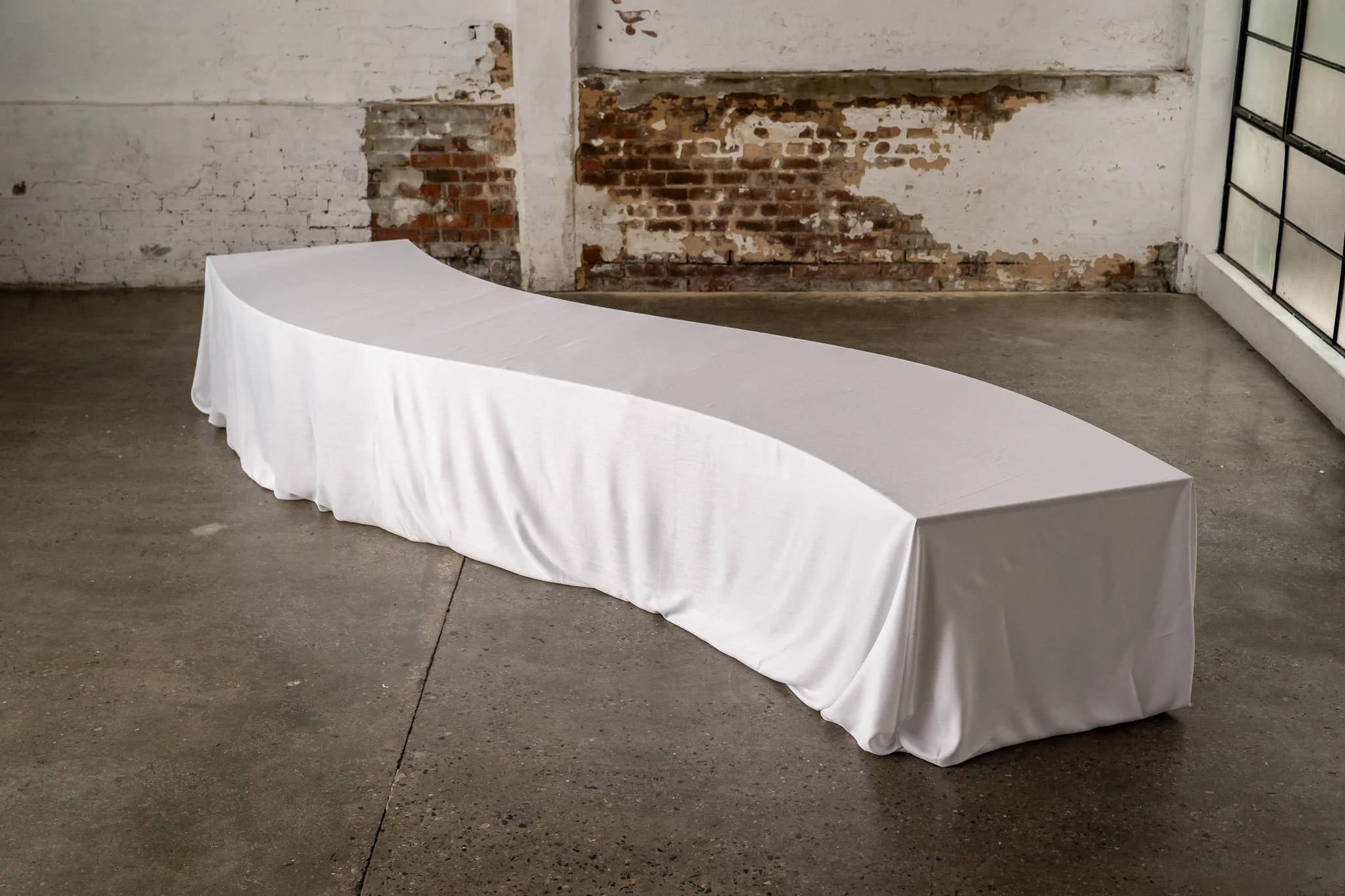 Curved wooden wedding table, set in a wave