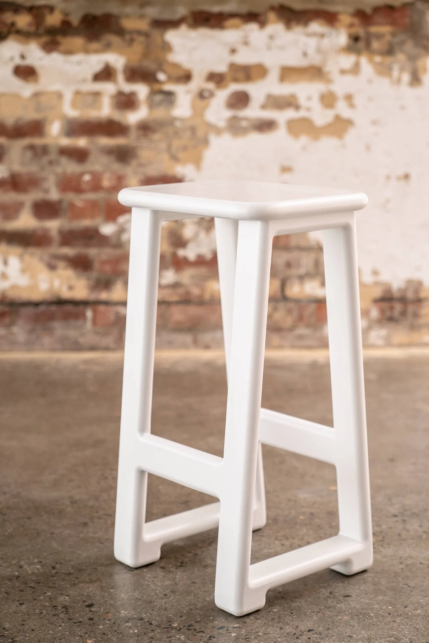 White bar stools arranged around a cocktail table