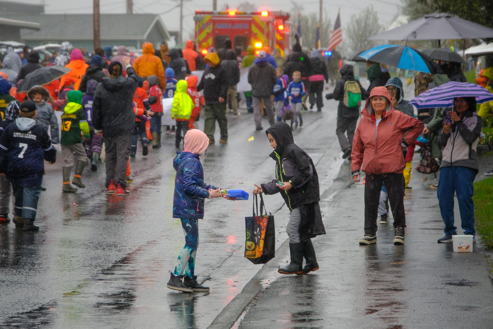 4. One child handing goodies to another at the Crab Fest Parade, May 27, 2023.  (Brian Venua, KMXT).jpg