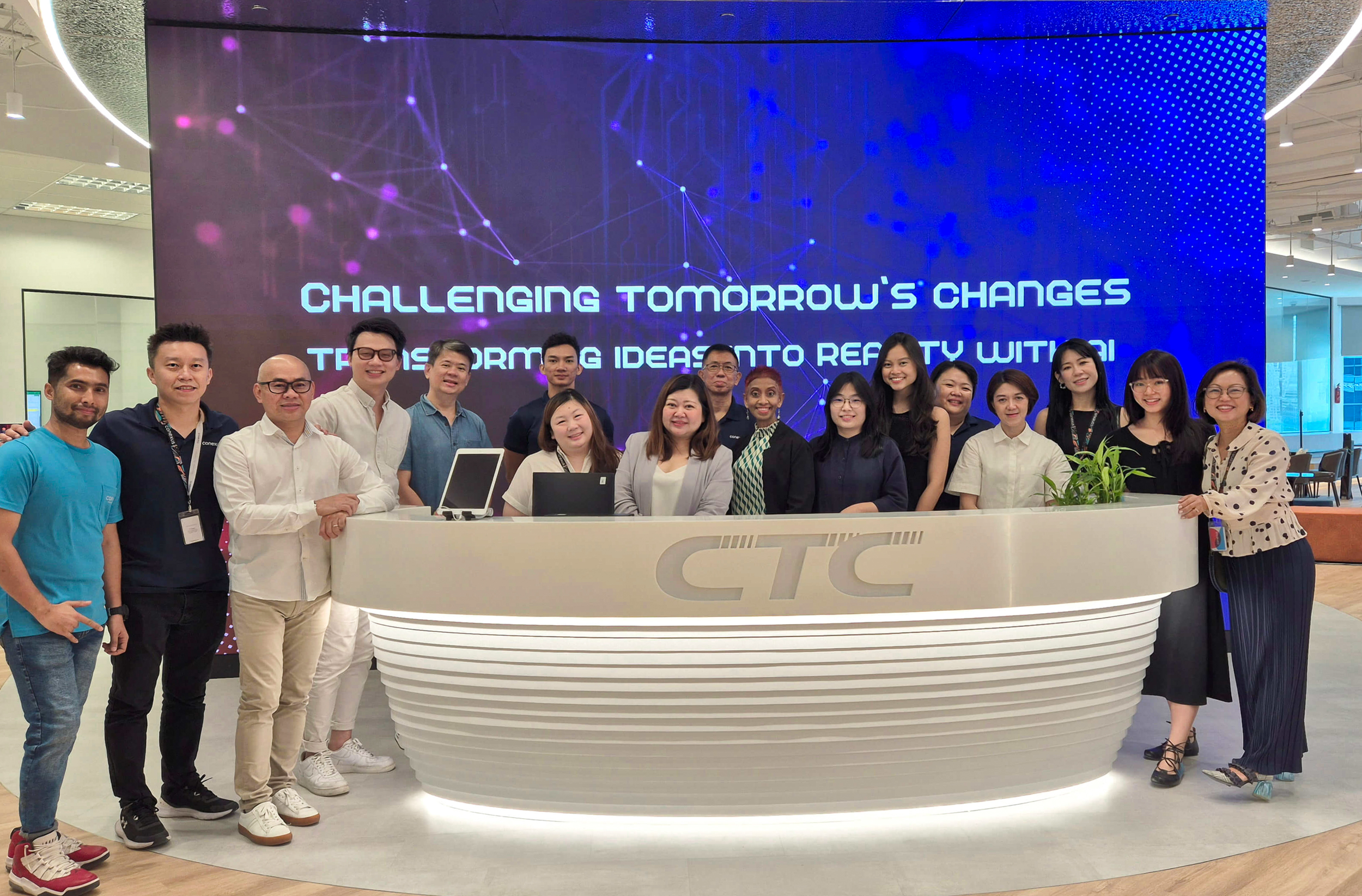 团队协作和喜悦笑容在时尚新空间下交相辉映:CTC Global 与 Conexus 团队在前台举杯庆祝,为项目画上圆满句号。