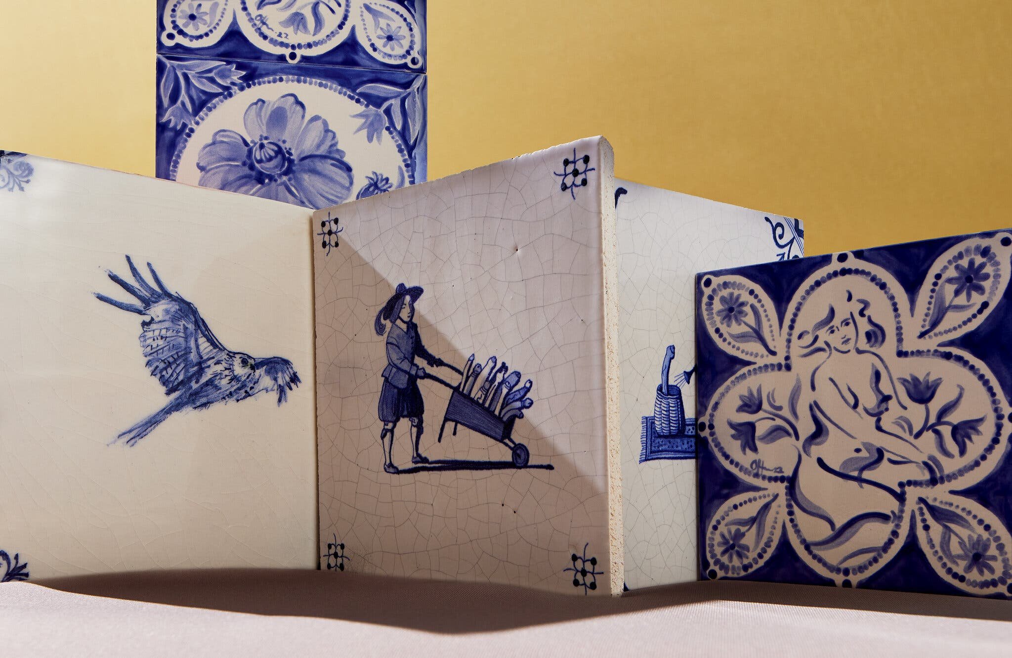 Delft tiles: an owl in flight; a boy with a barrow; a nude.
