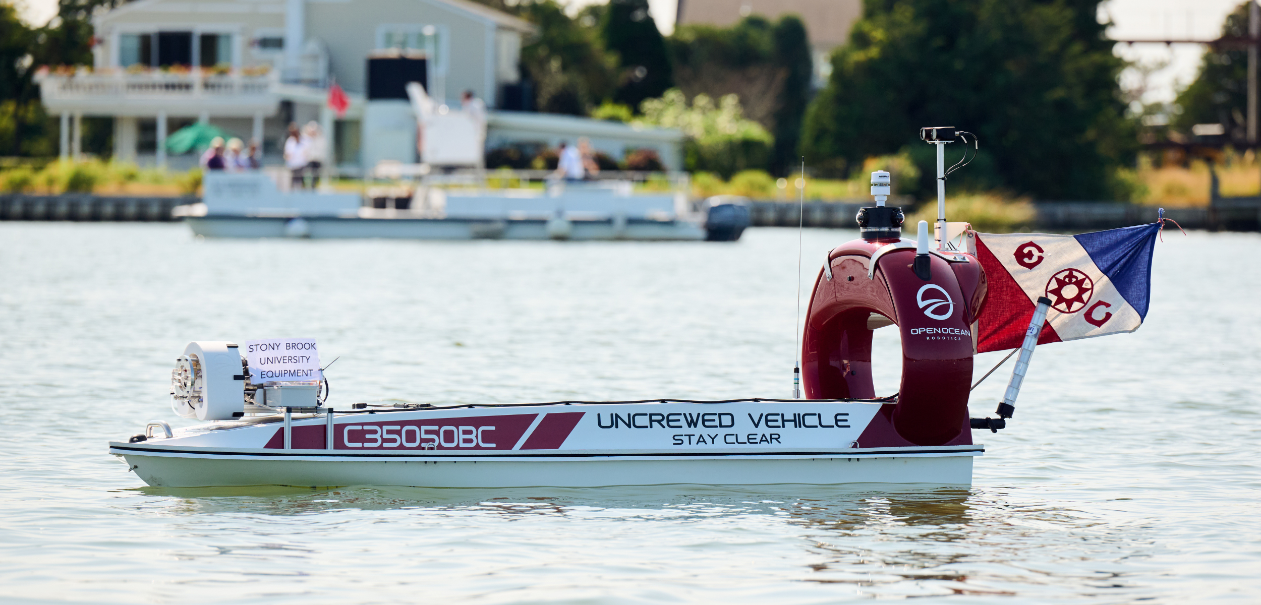DataXplorer, a 12-foot Unscrewed Surface Vessel outfitted with an environmental DNA (eDNA) sampler. The flag denotes the Explorers Club expedition for this project. 