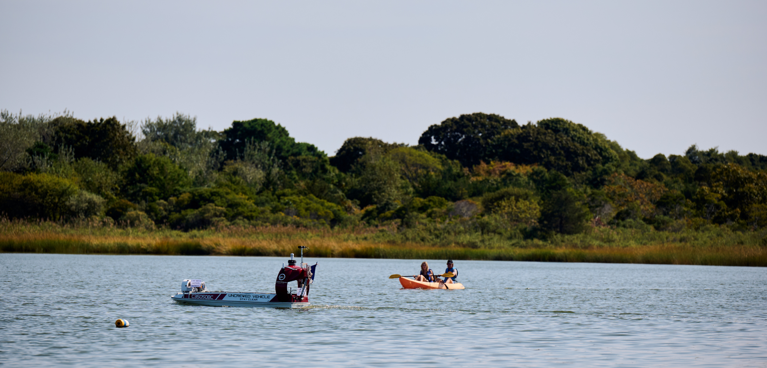 DataXplorer, a 12-foot Unscrewed Surface Vessel outfitted with an environmental DNA (eDNA) sampler. The flag denotes the Explorers Club expedition for this project. 