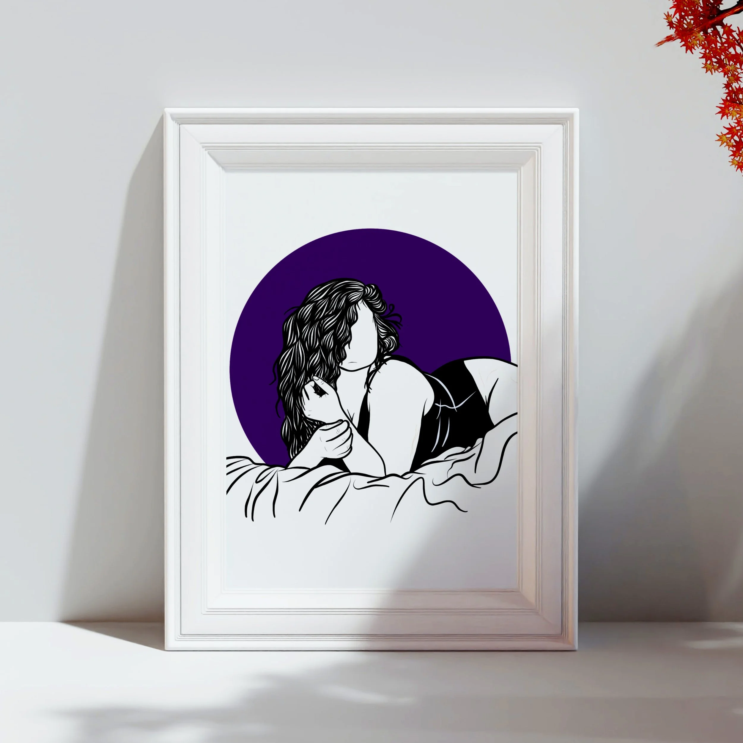 A minimalistic line art illustration of a woman with long hair, sitting and resting her head on her knees, set against a purple background, printed on a rectangular piece of art hanging on a plain wall with white crown molding. A red-orange plant is 