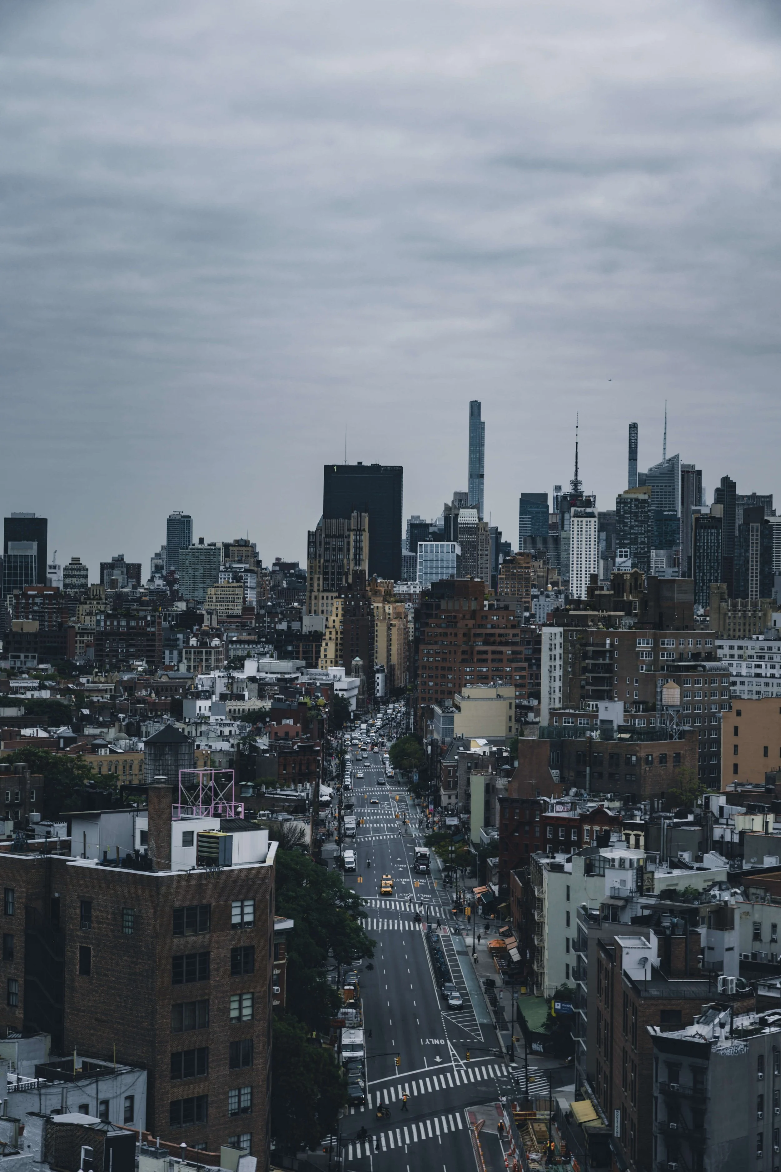 Overcast cityscape of New York City with tall skyscrapers, busy streets, and buildings in various architectural styles.