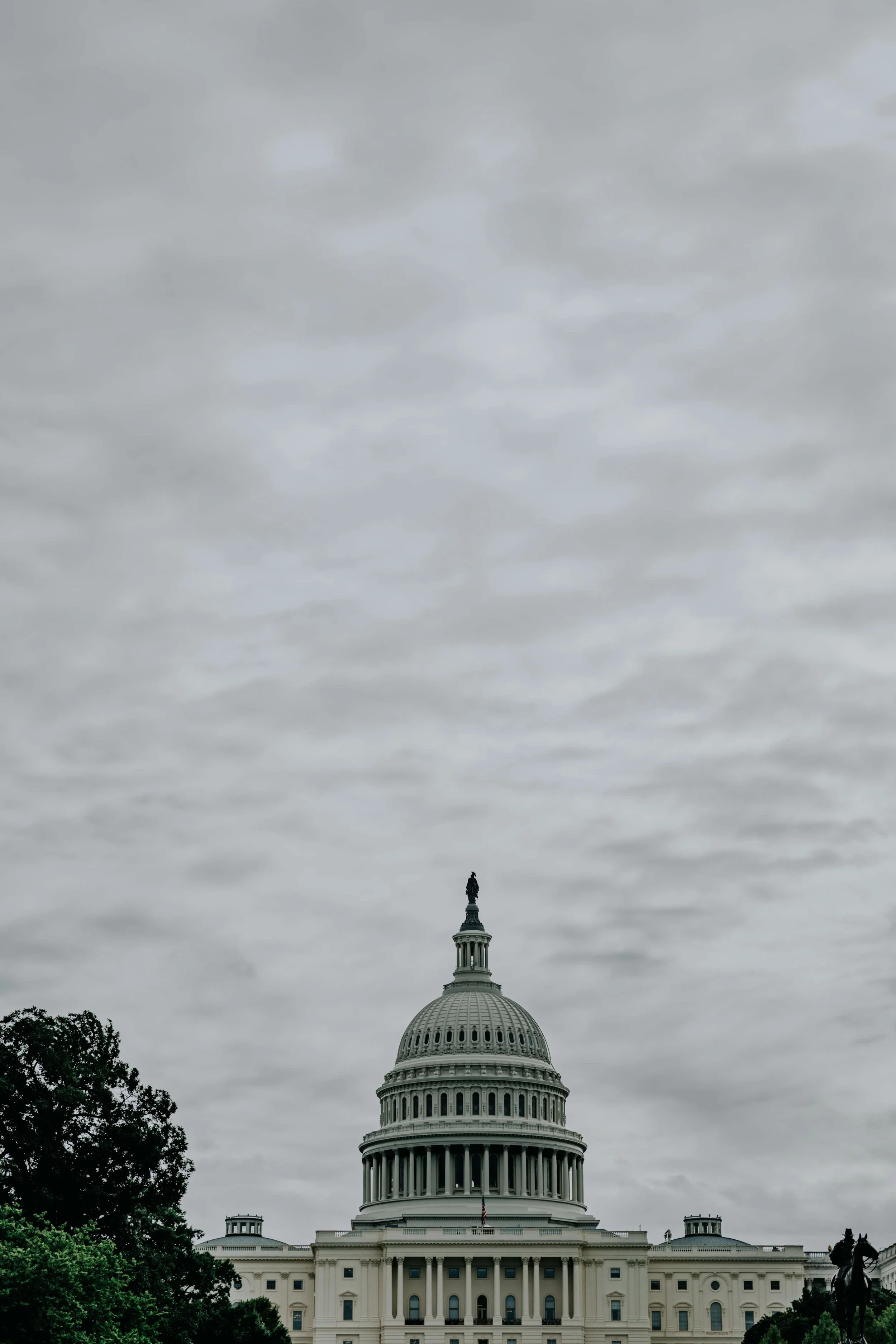 The United States Capitol building with a cloudy sky in the background.