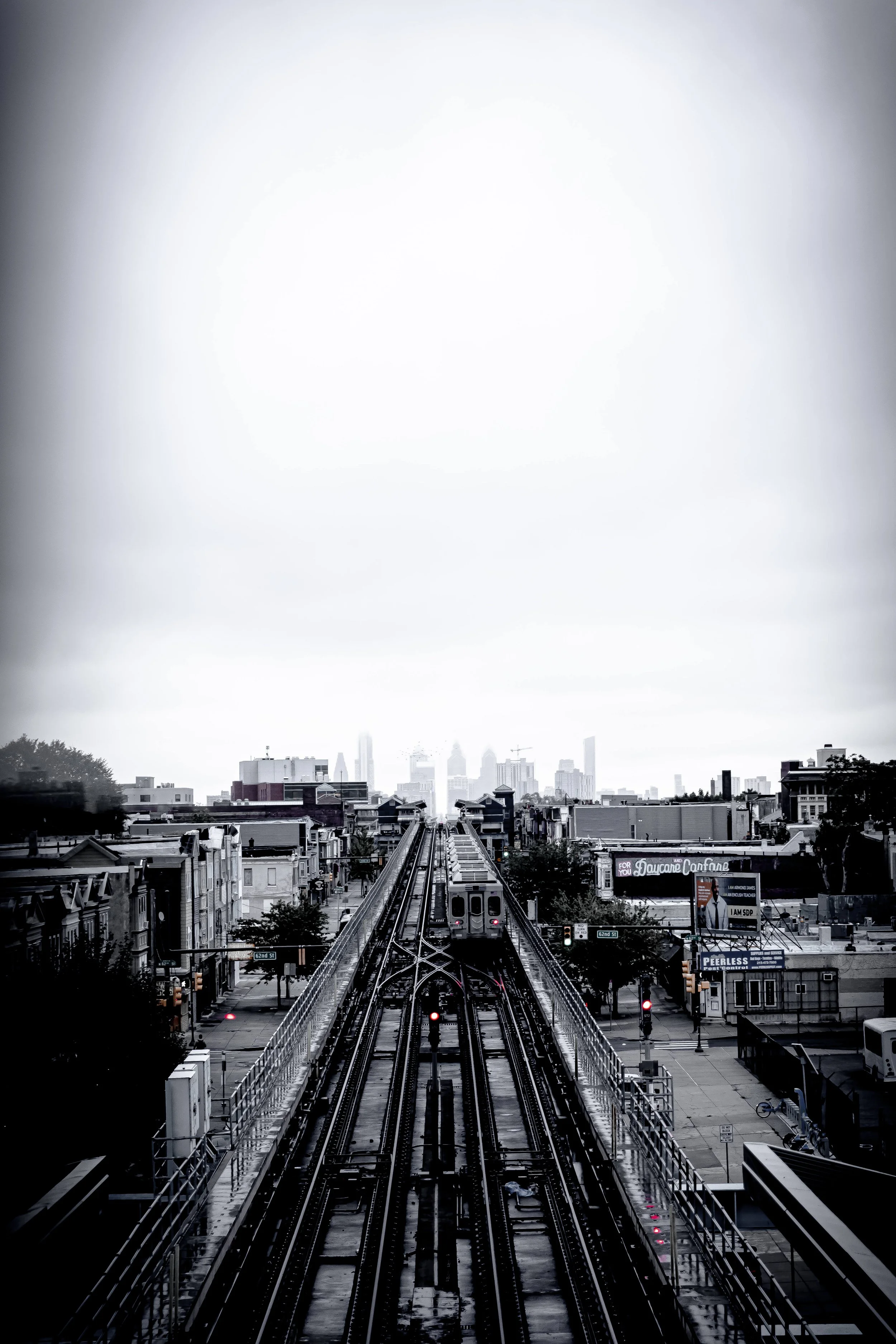 Cityscape view from above the train tracks, with buildings and the skyline in the distance, overcast sky.