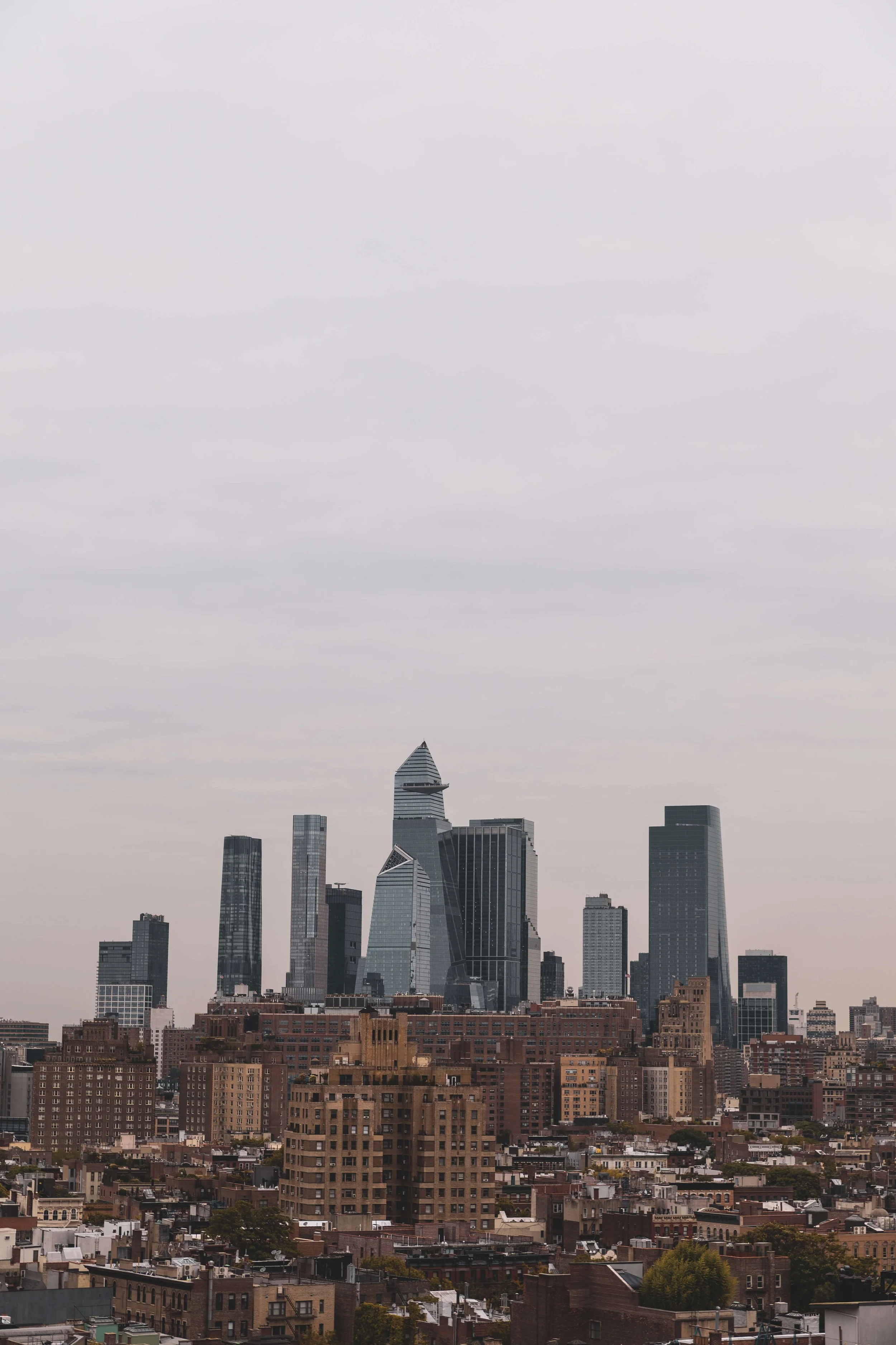 Cityscape of New York City with skyscrapers under a cloudy sky.