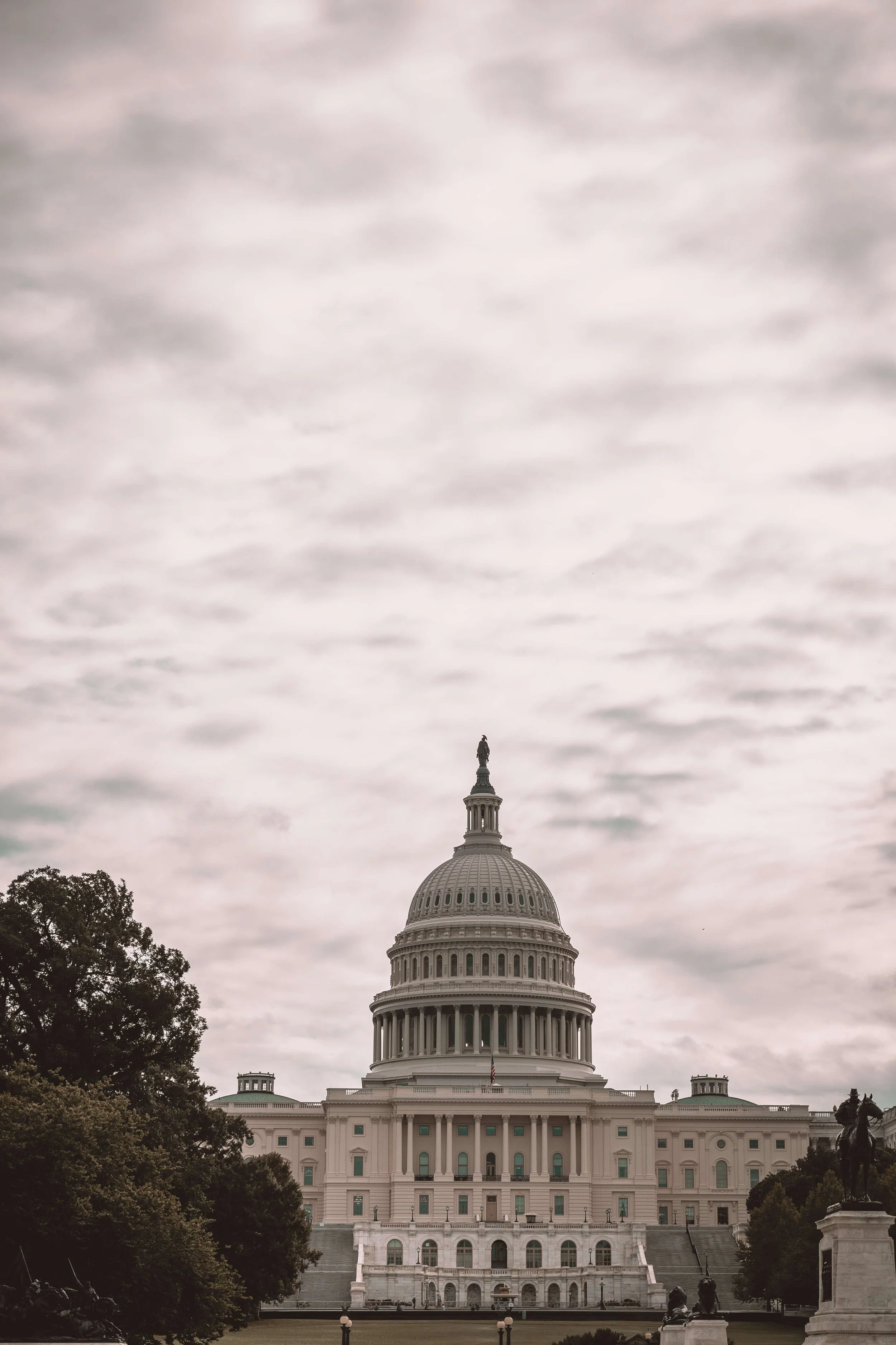 The United States Capitol building with a cloudy sky overhead.