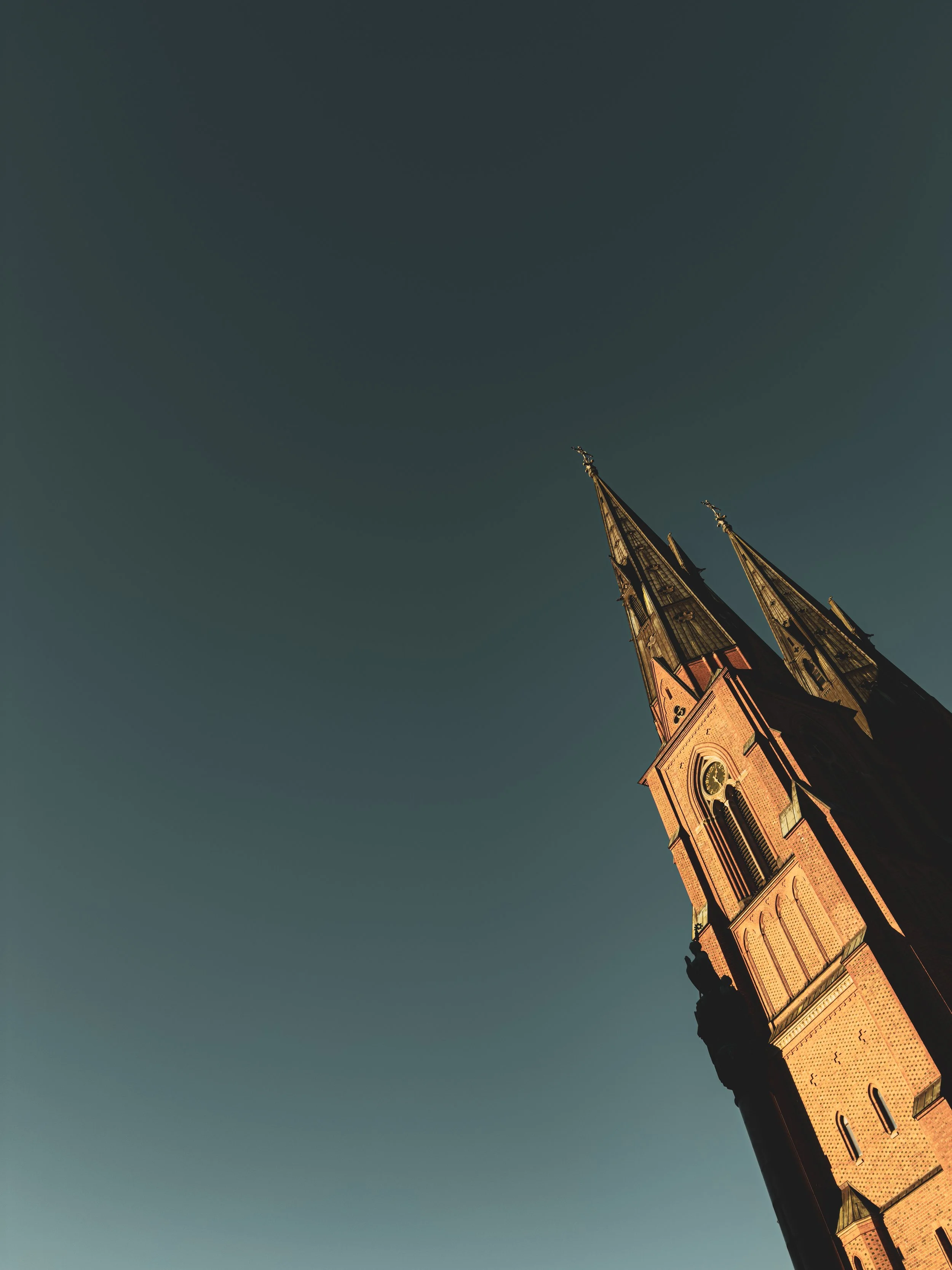 Tall, historic church with two pointed spires against a clear sky